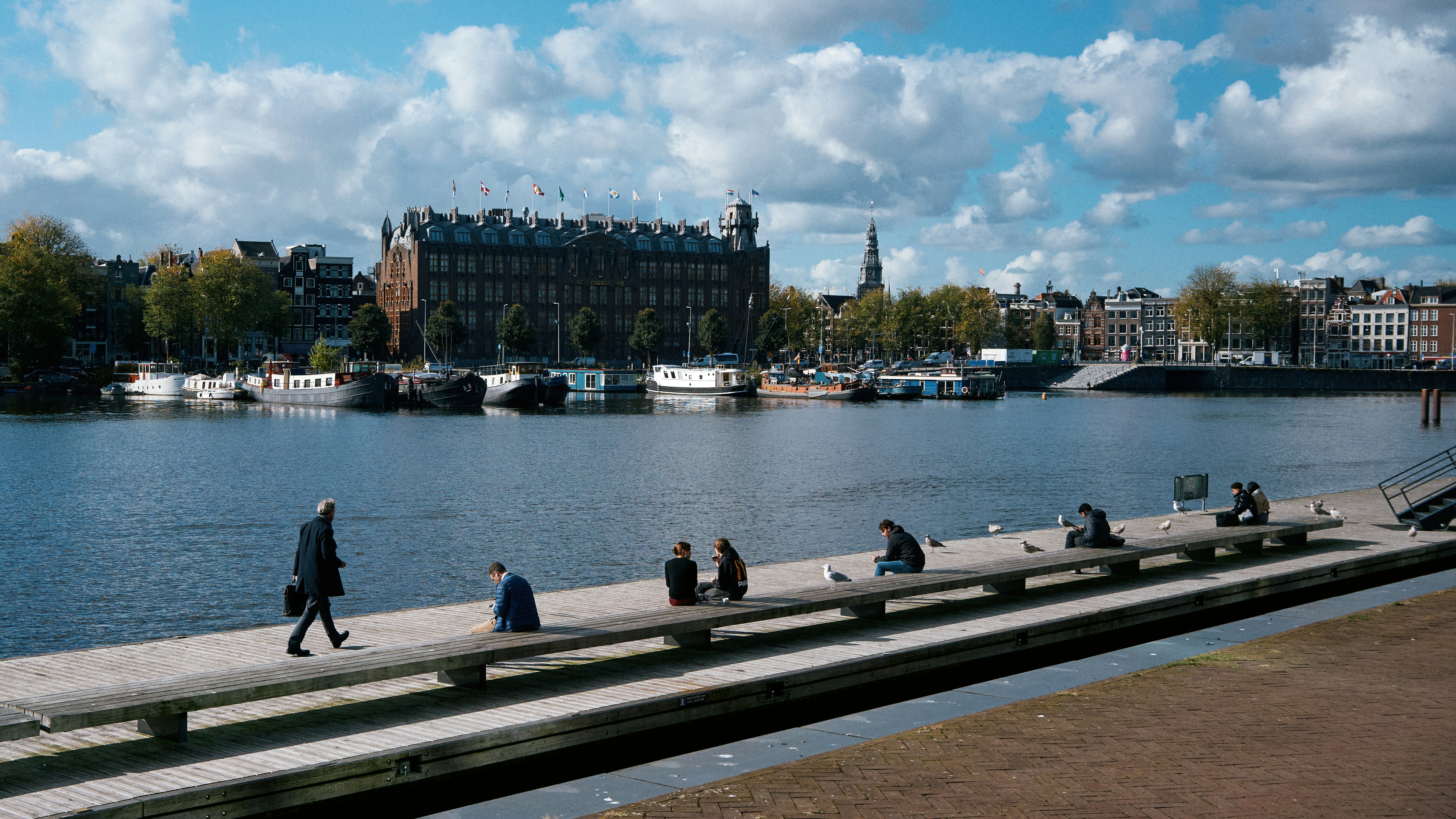 A group of people walking across a bridge over a river