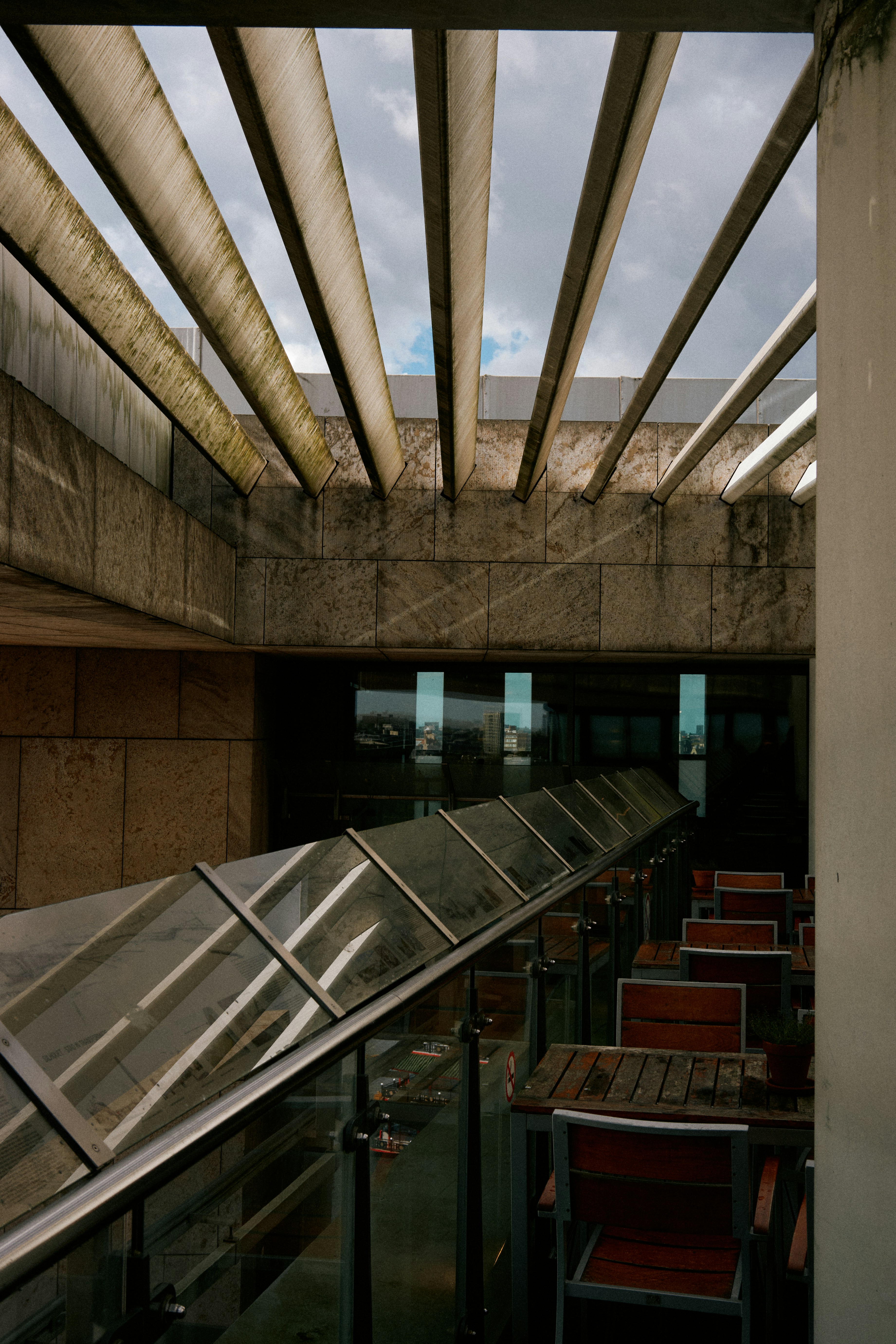 A row of red chairs sitting under a metal roof
