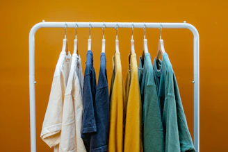 A rack that has a bunch of clothes hanging on it
