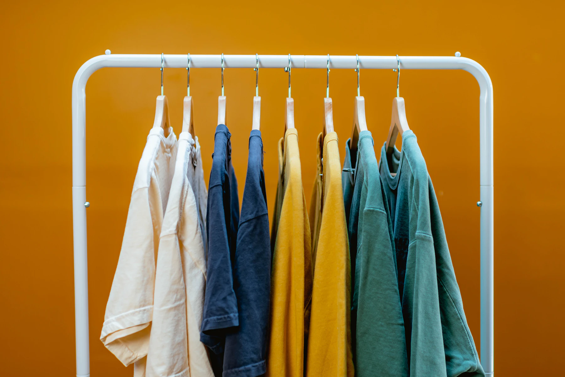 A rack that has a bunch of clothes hanging on it