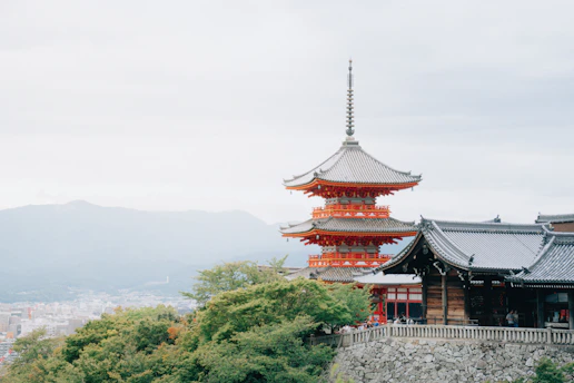 A tall building sitting on top of a lush green hillside