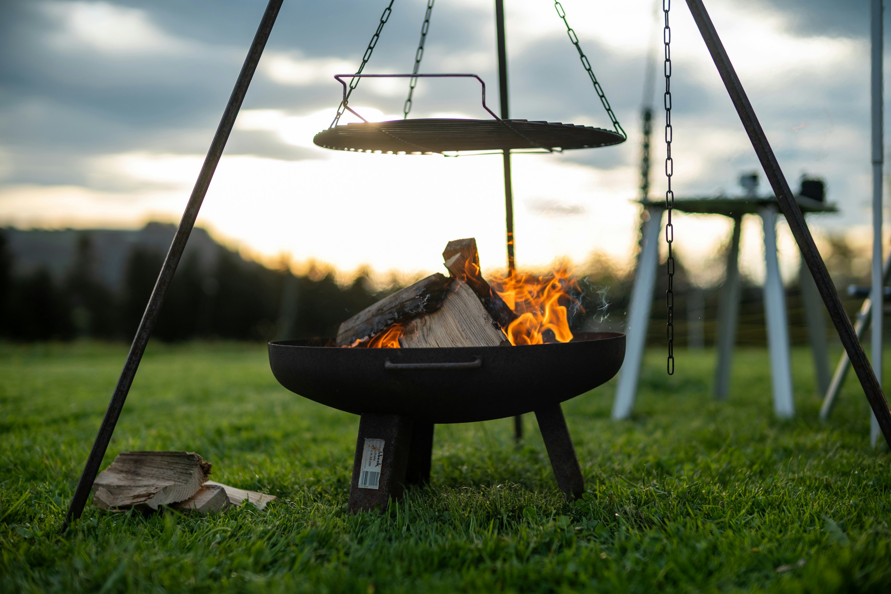 A fire pit sitting on top of a lush green field