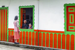 A woman standing outside of a colorful building