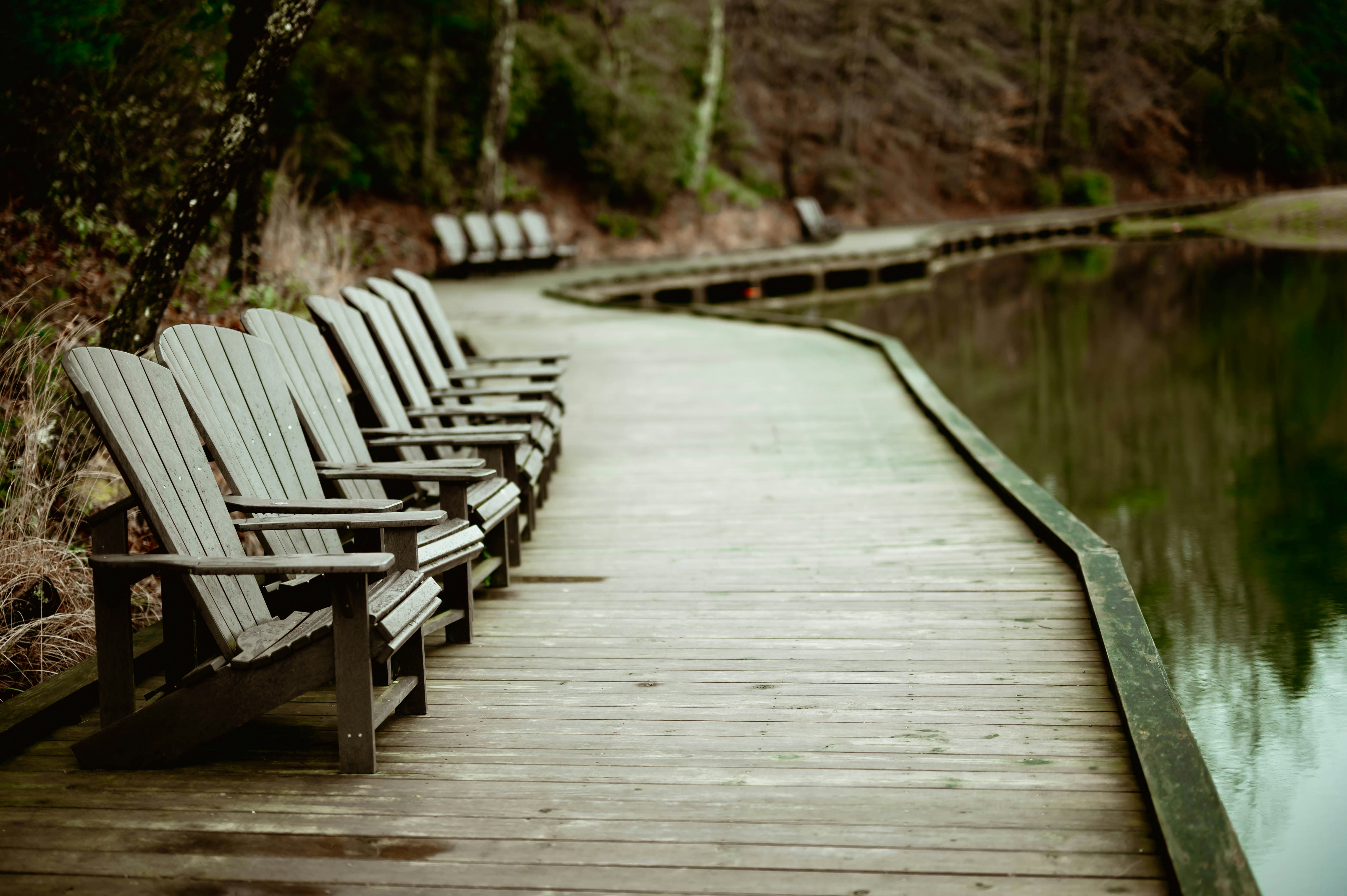 A row of chairs sitting on top of a wooden pier