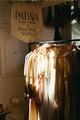 A rack of clothes in front of a window