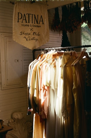 A rack of clothes in front of a window