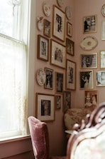 A room with a chair and a wall with pictures on it