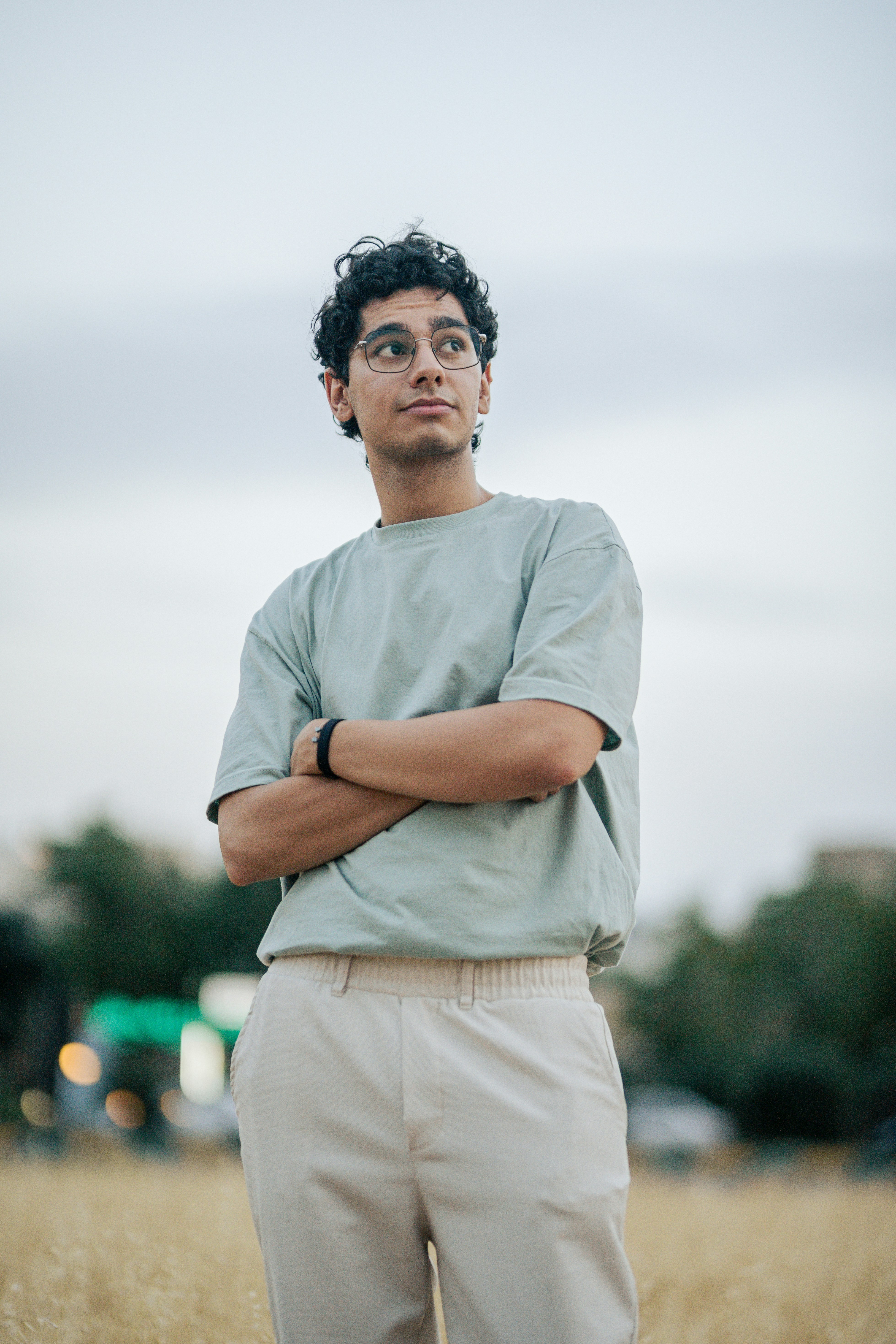 Un hombre de pie en un campo con los brazos cruzados