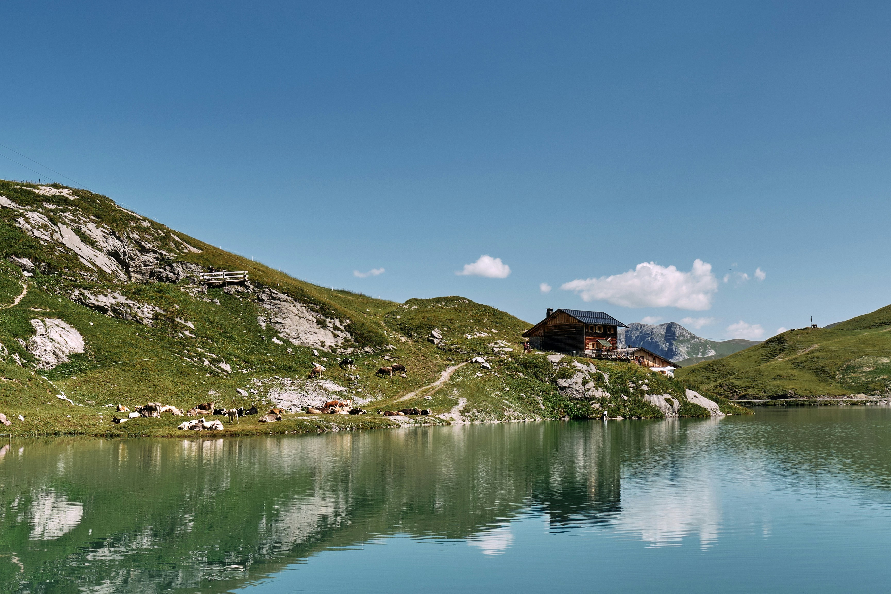 A lake surrounded by mountains and a house