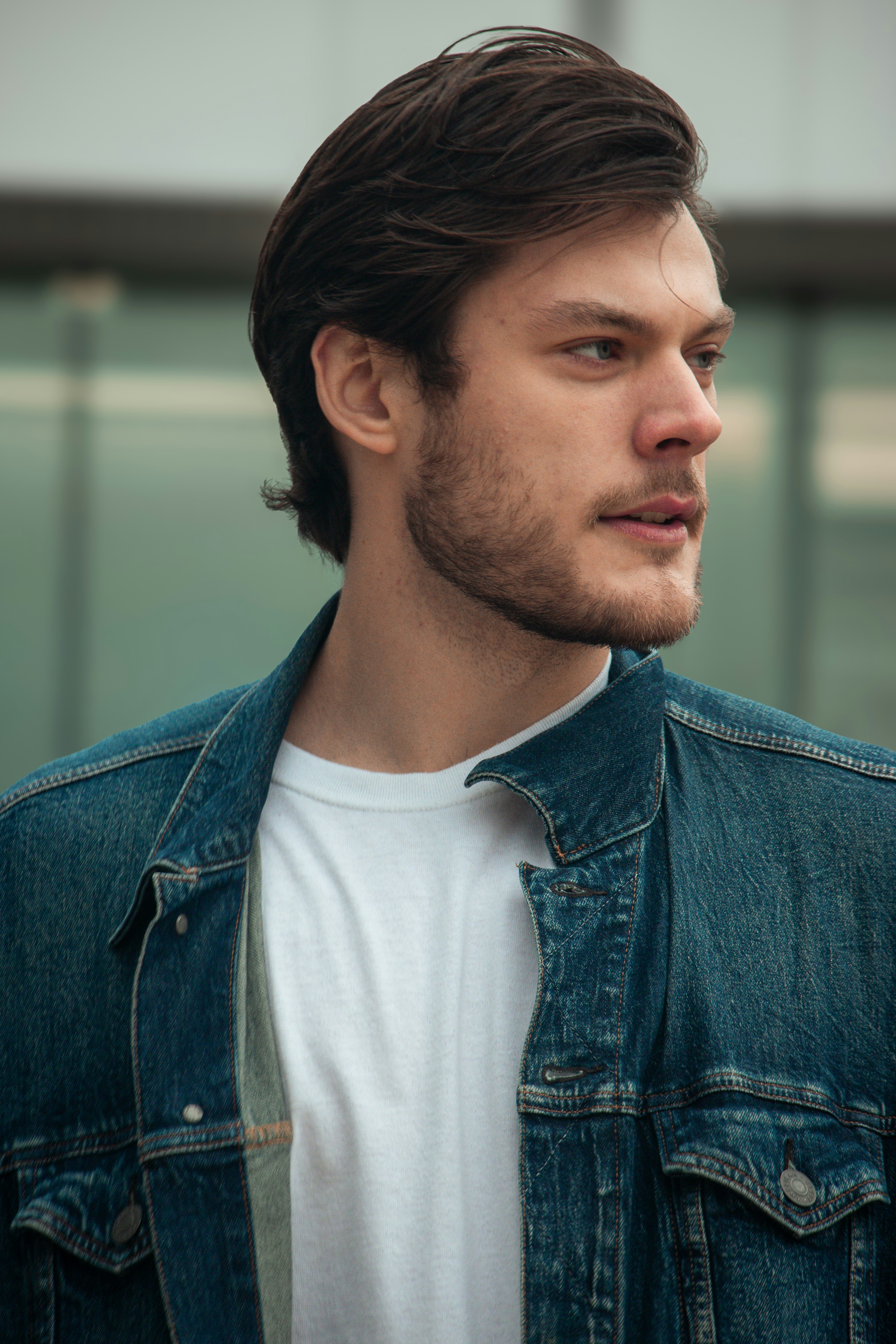 A man in a denim jacket looking off into the distance