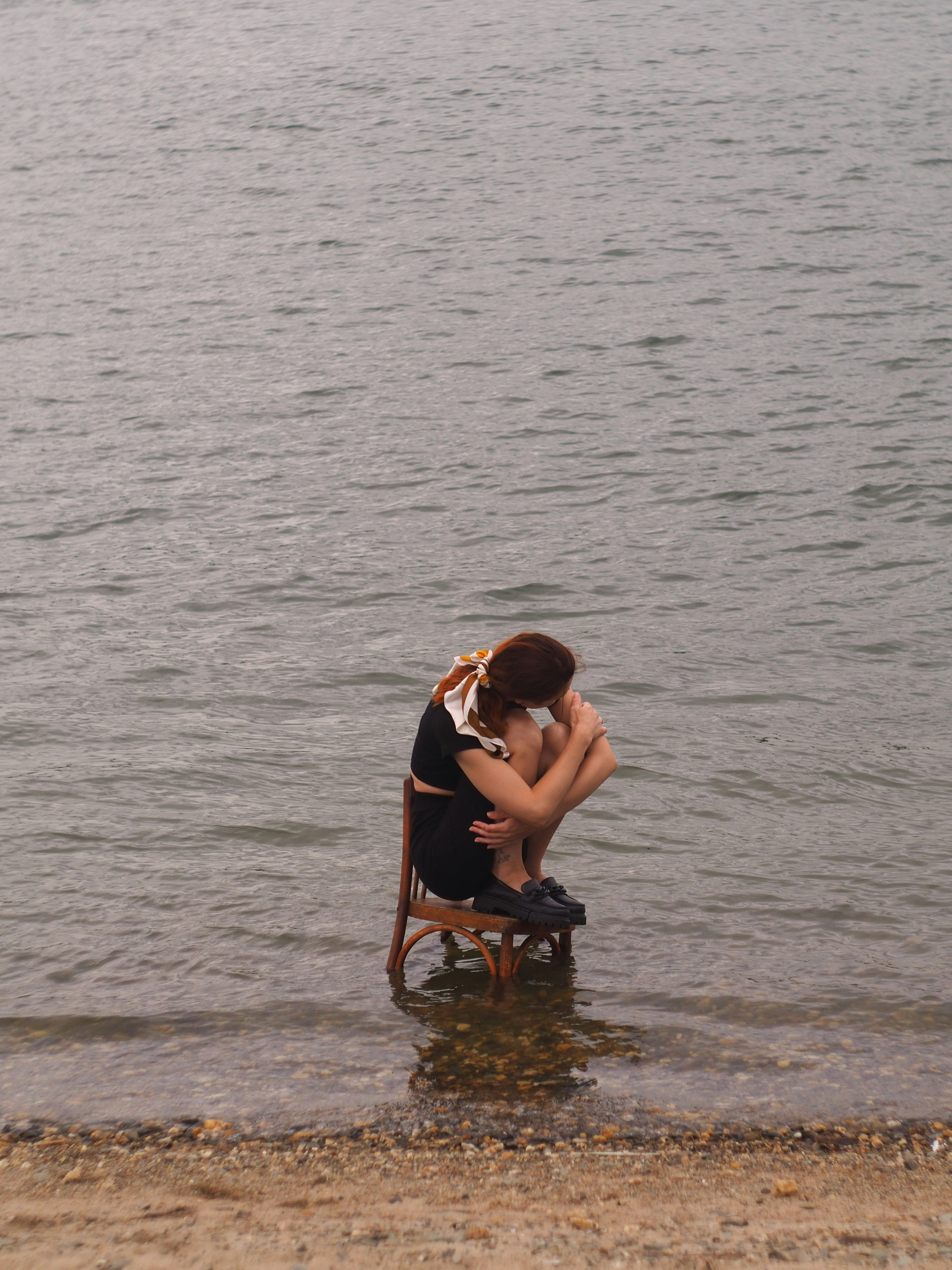 A woman sitting on a chair in the water photo – Free Beach Image on ...