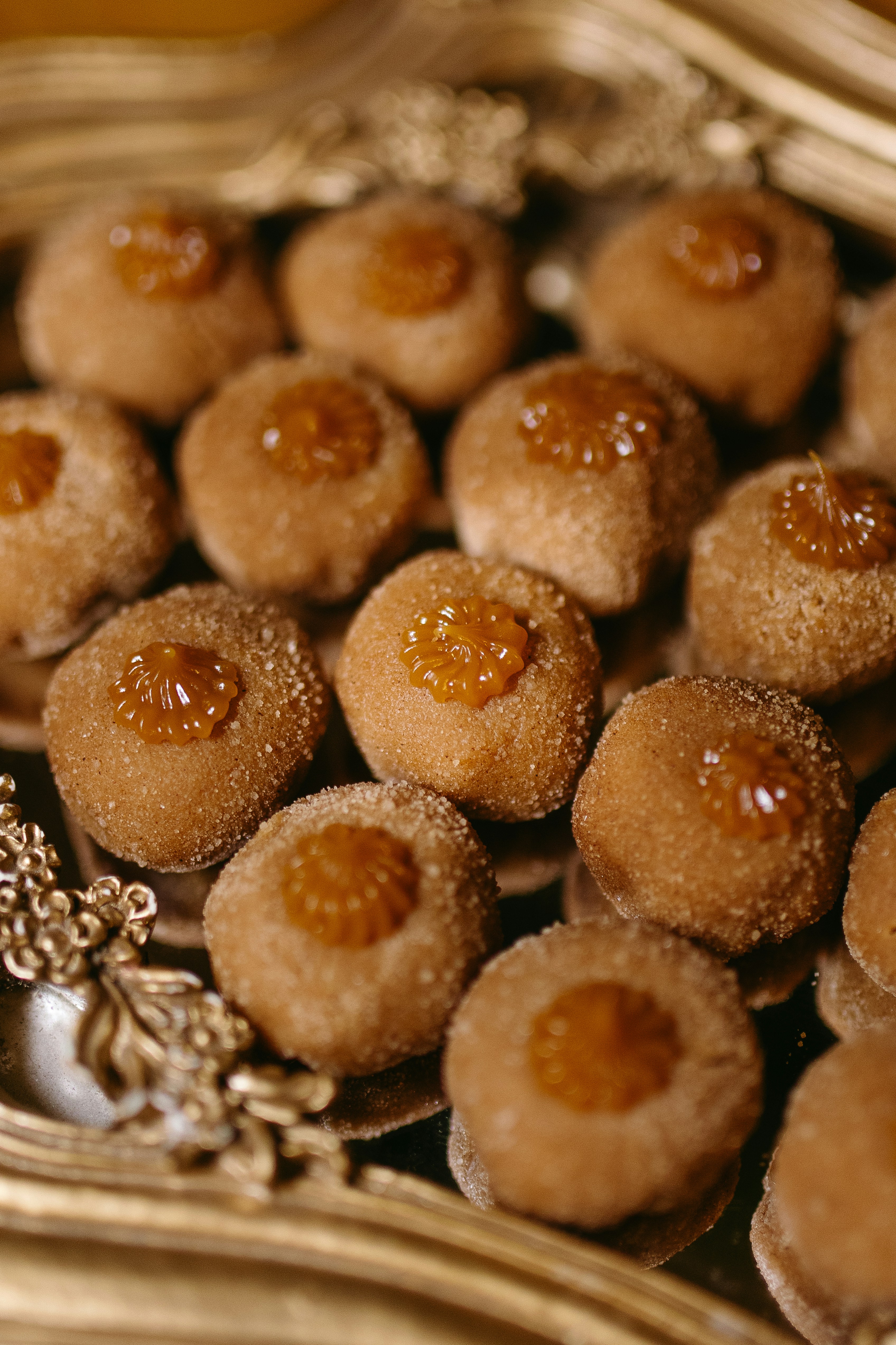 Kue nastar bulat keemasan dengan isian selai nanas, pencahayaan bakery hangat, latar belakang putih bersih
