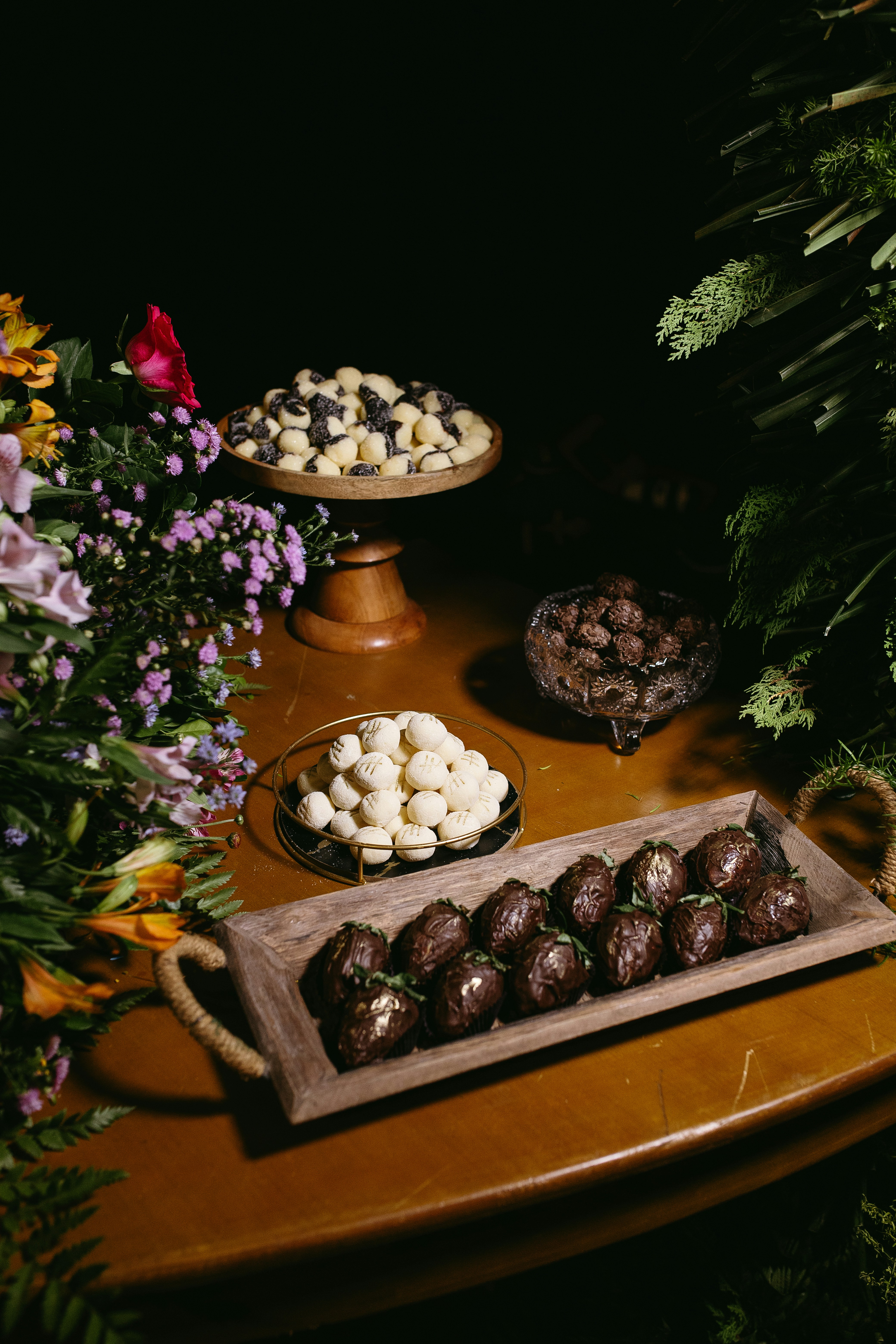 A table topped with a tray of chocolate covered desserts