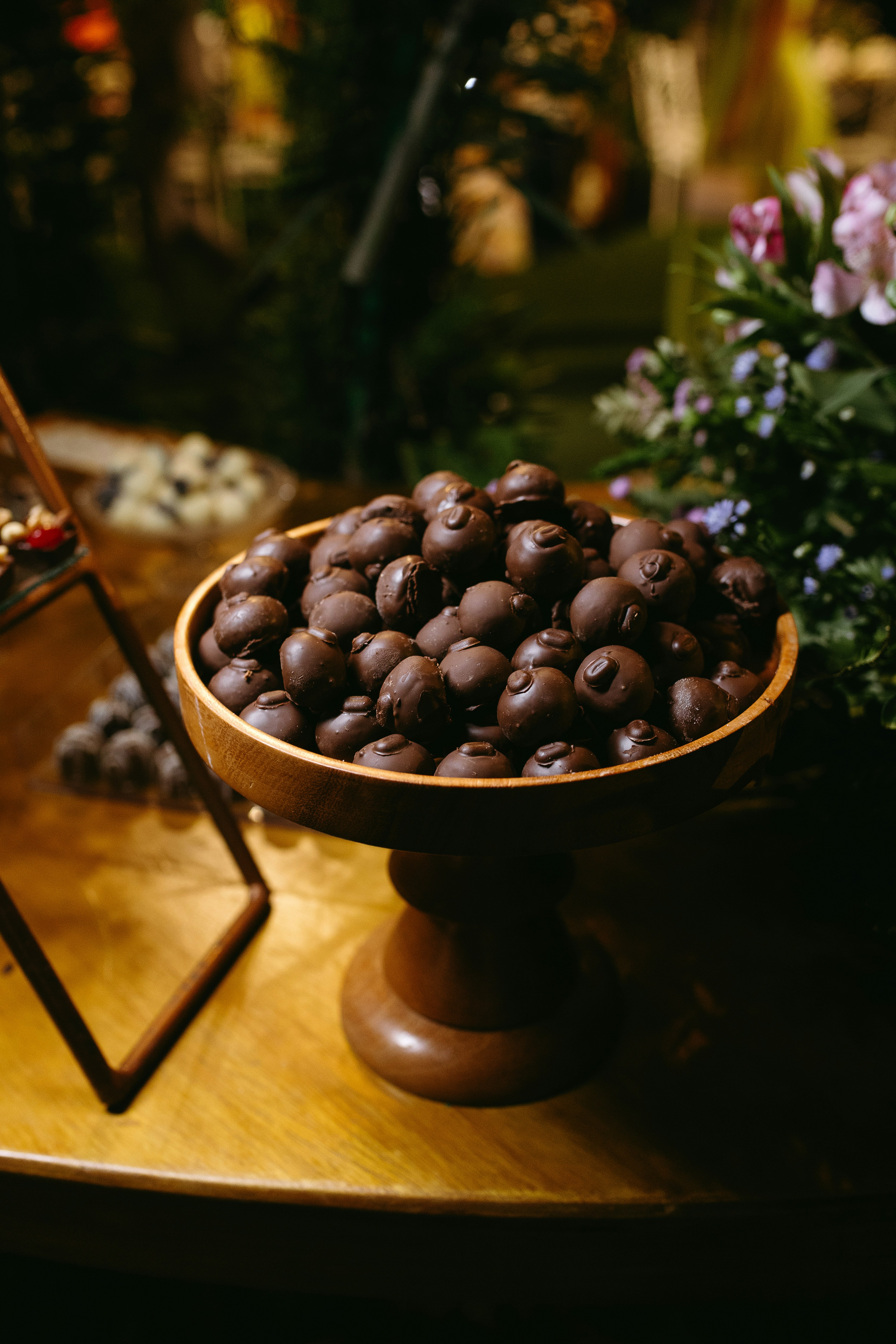 A wooden table topped with a bowl of chocolate