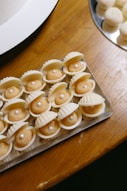 A table topped with a tray of shell shaped desserts