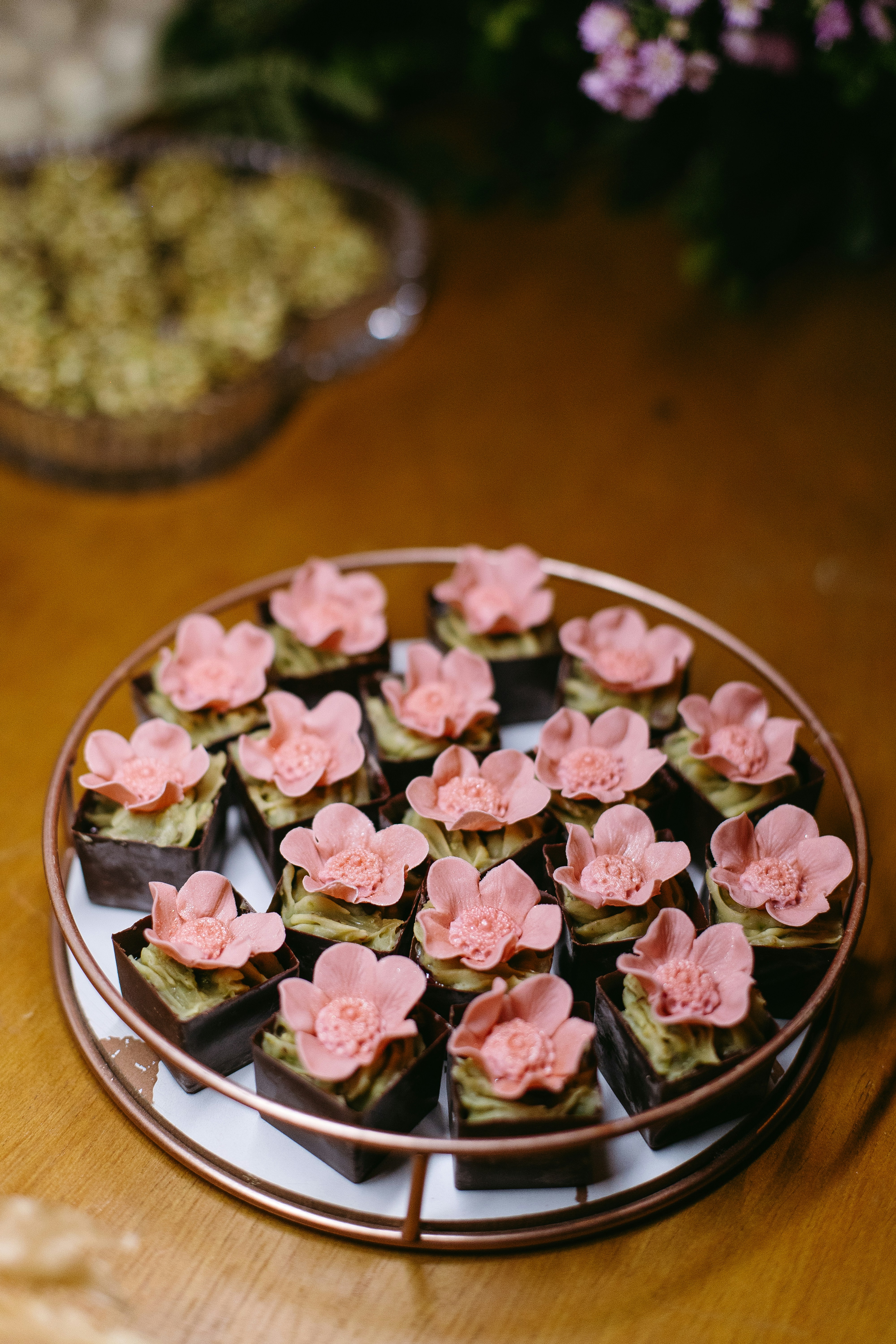 A plate of cupcakes with pink flowers on them
