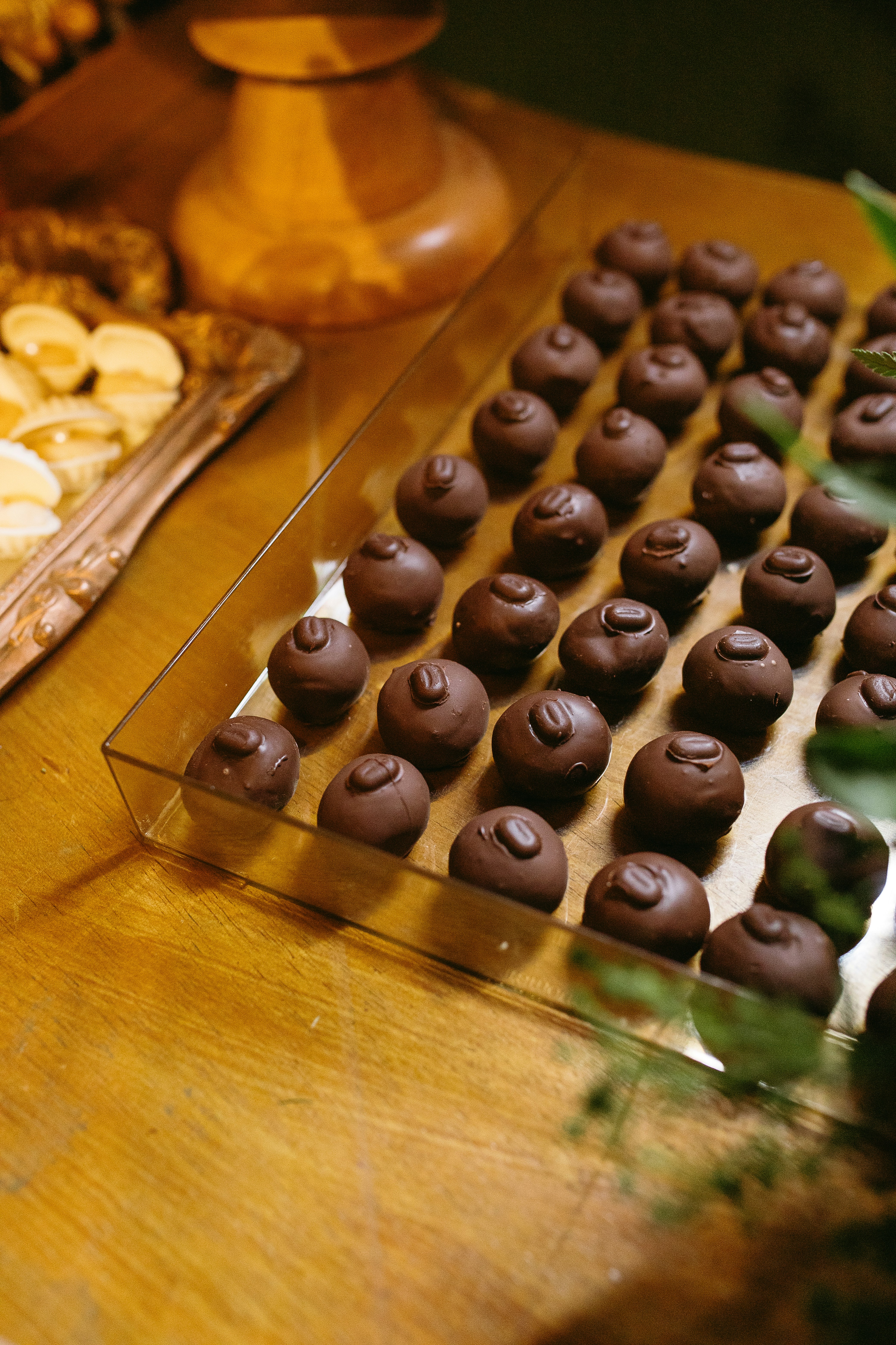 A wooden table topped with a tray of chocolate covered cookies