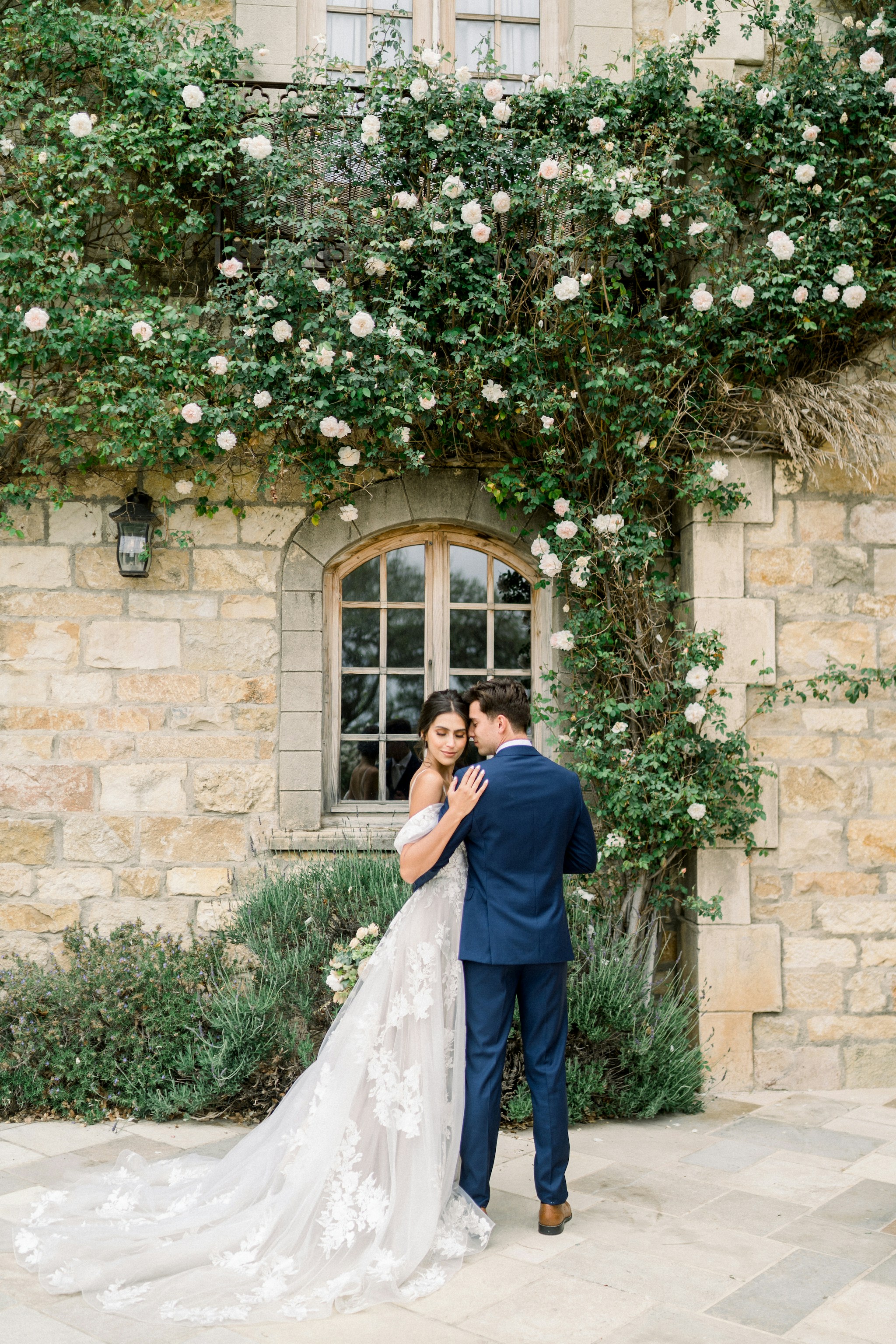 A bride and groom standing in front of a stone building photo – Free ...