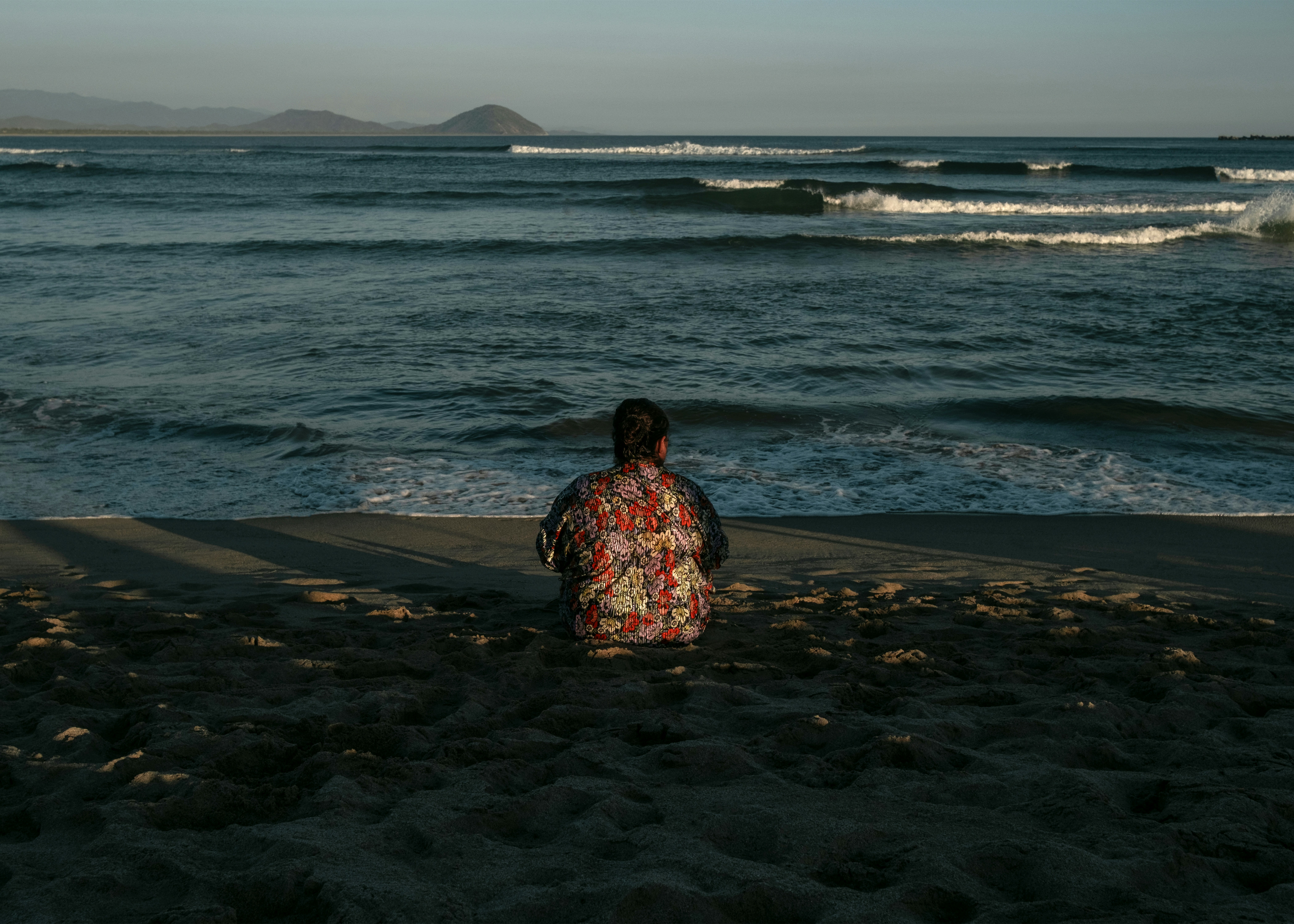 A person standing on a beach next to the ocean