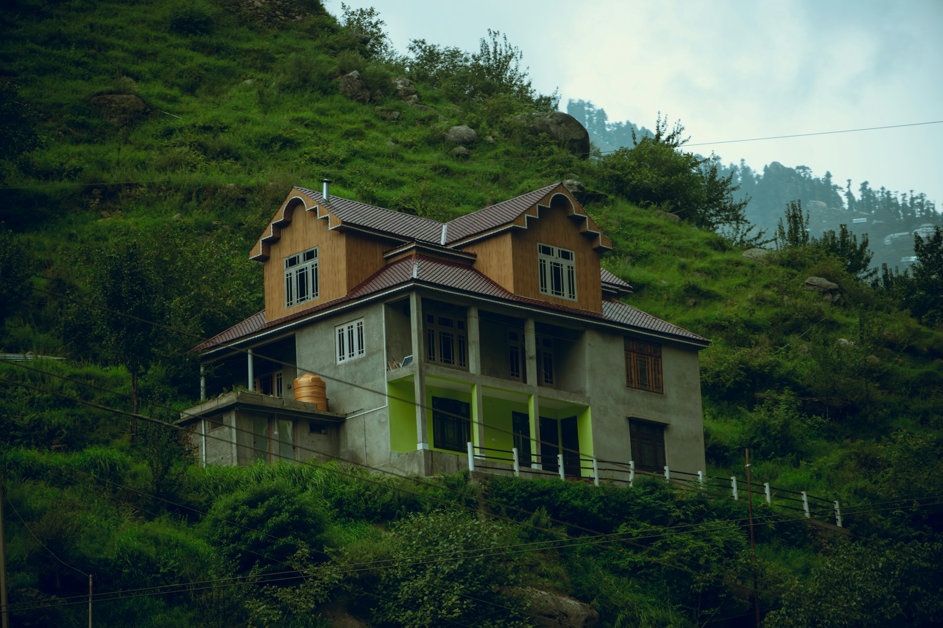 A house sitting on top of a lush green hillside