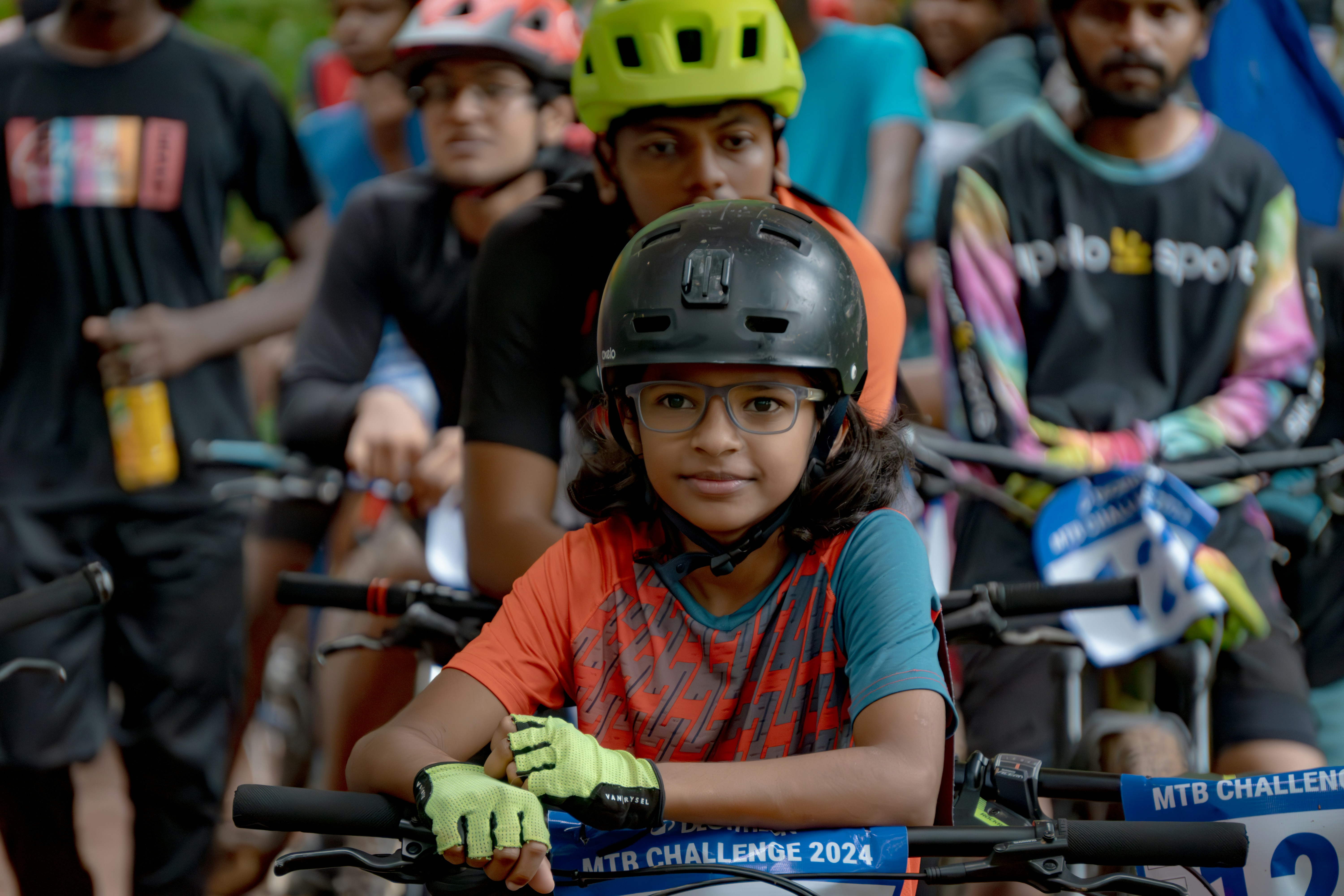 A group of people riding bikes down a street