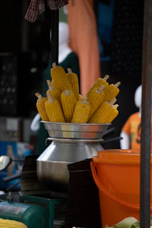 A bowl of corn sitting on top of a table