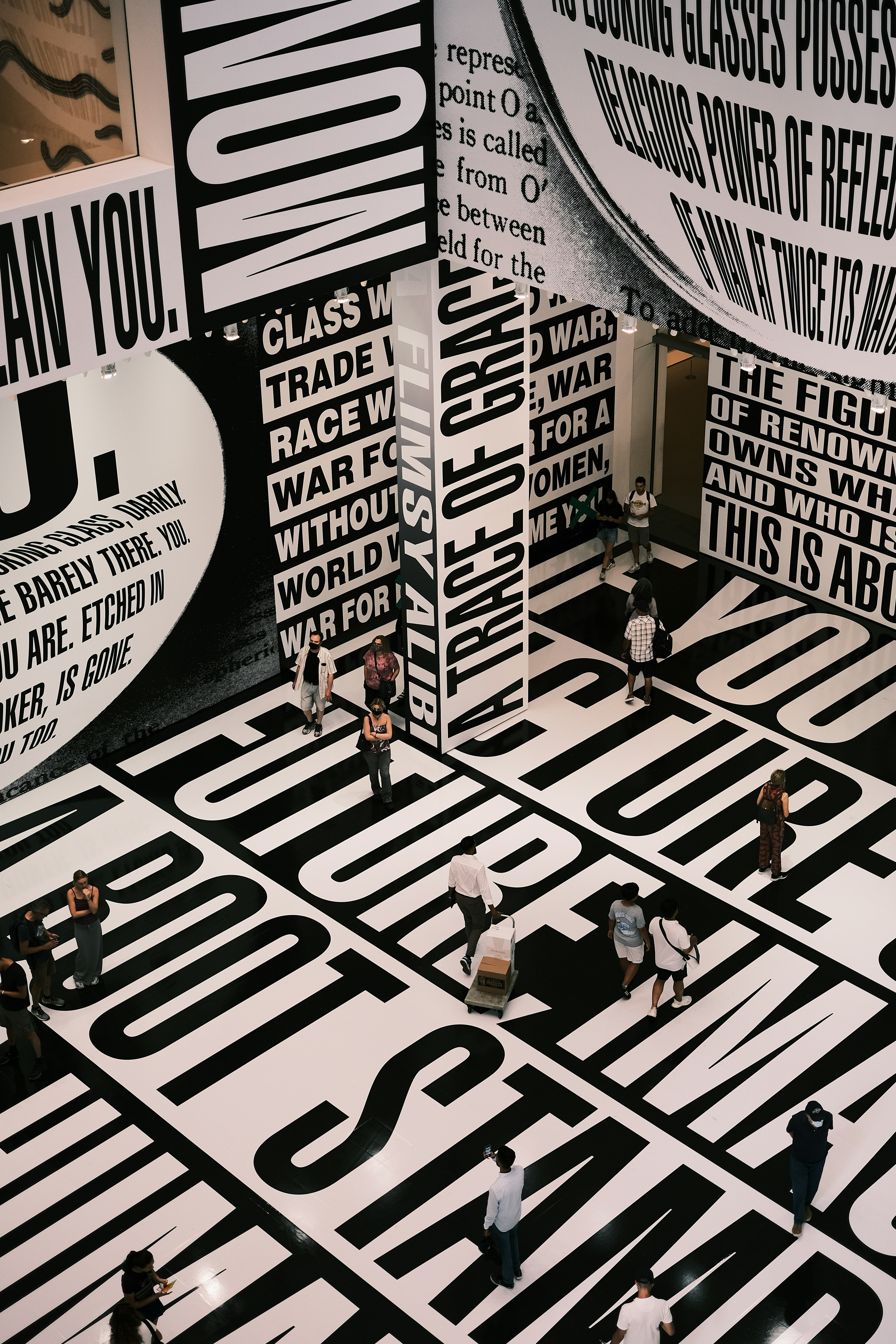 A group of people walking around a black and white room