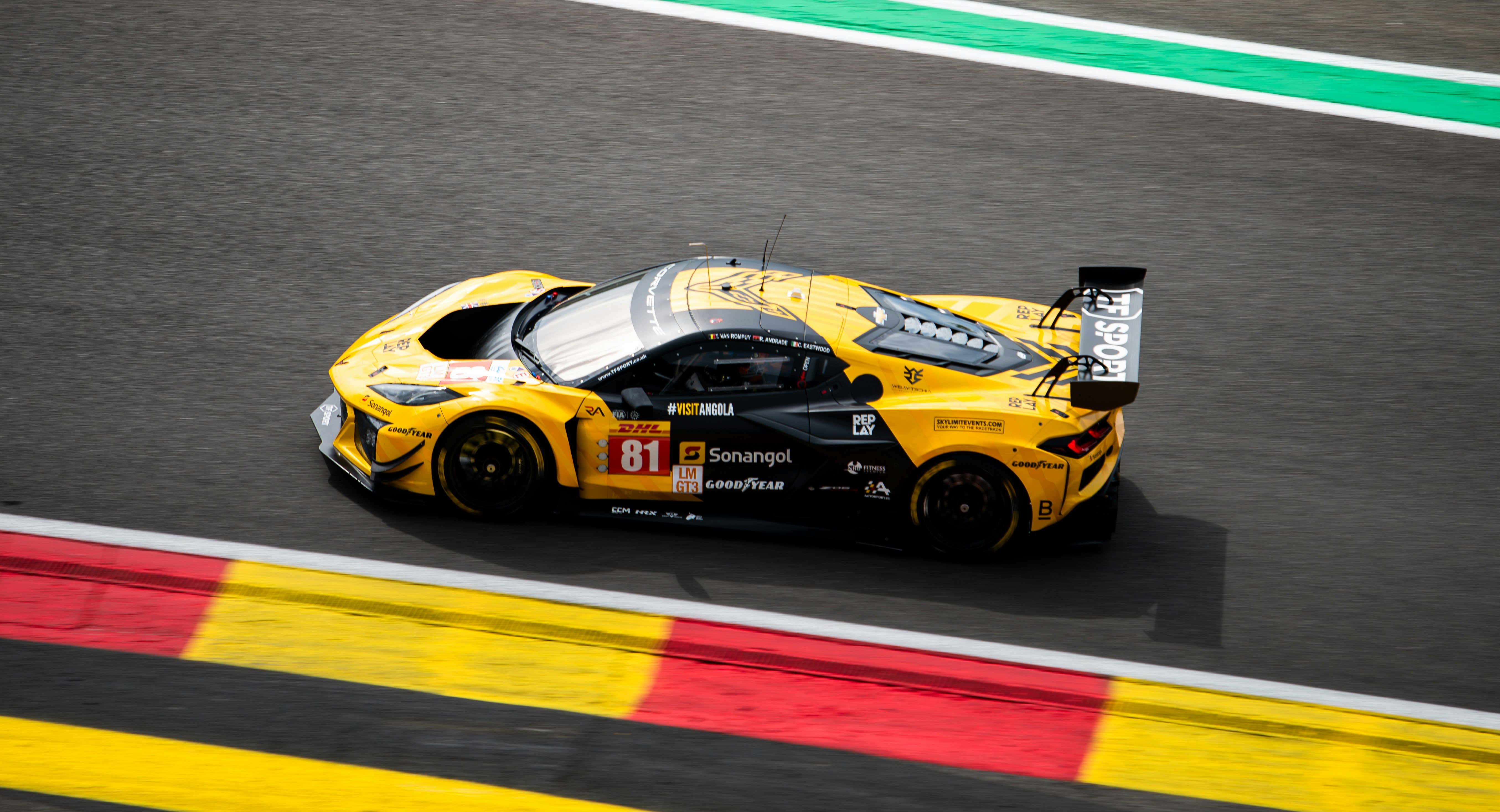 A yellow sports car driving on a race track