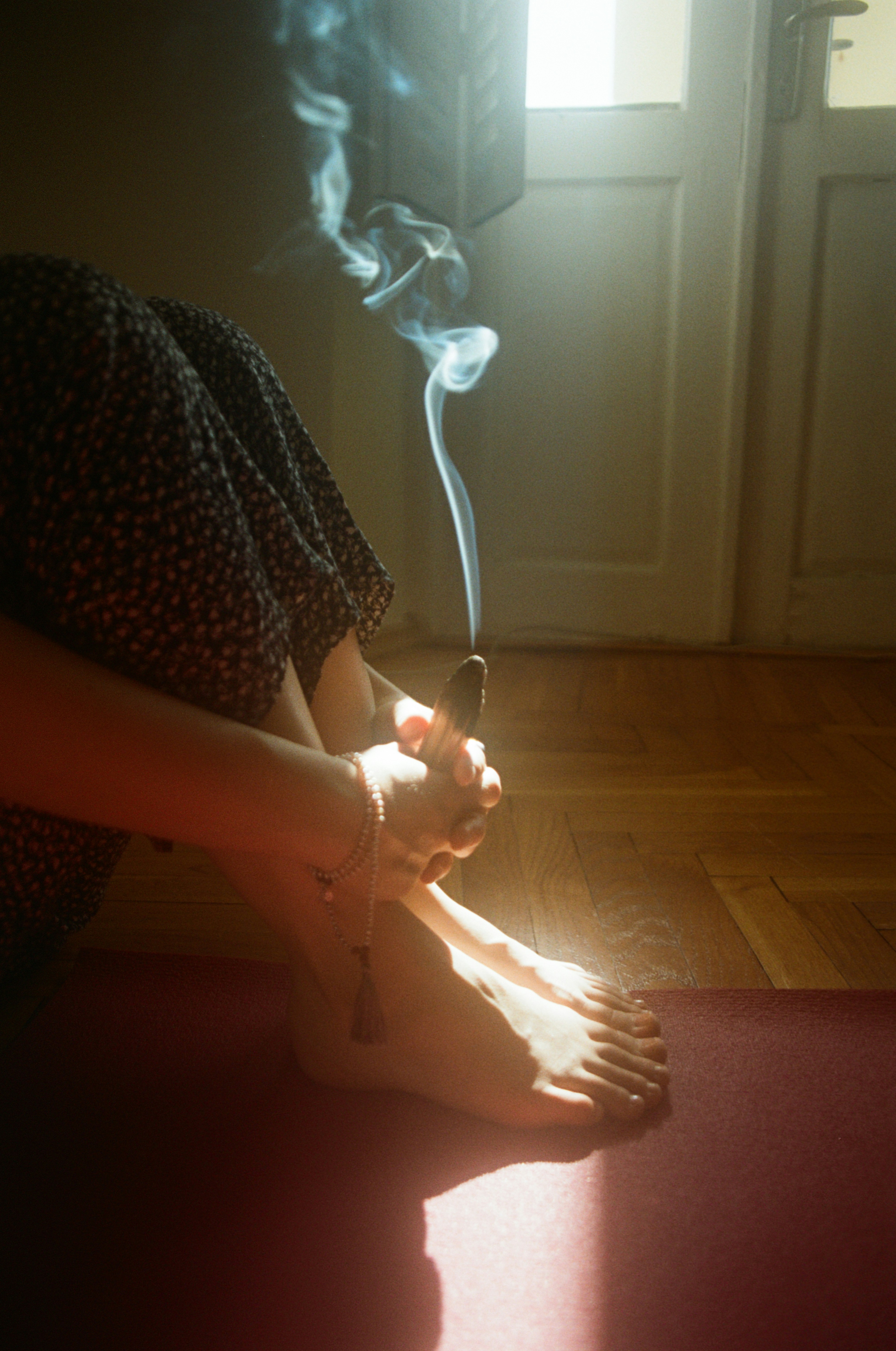 A woman sitting on the floor smoking a cigarette