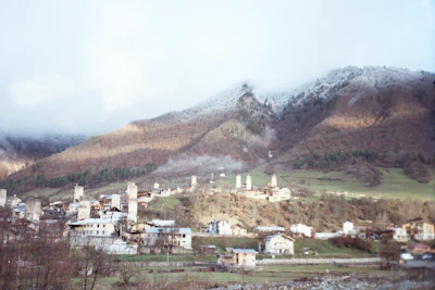 The stone Svan towers of Mestia under a cloud-covered mountain