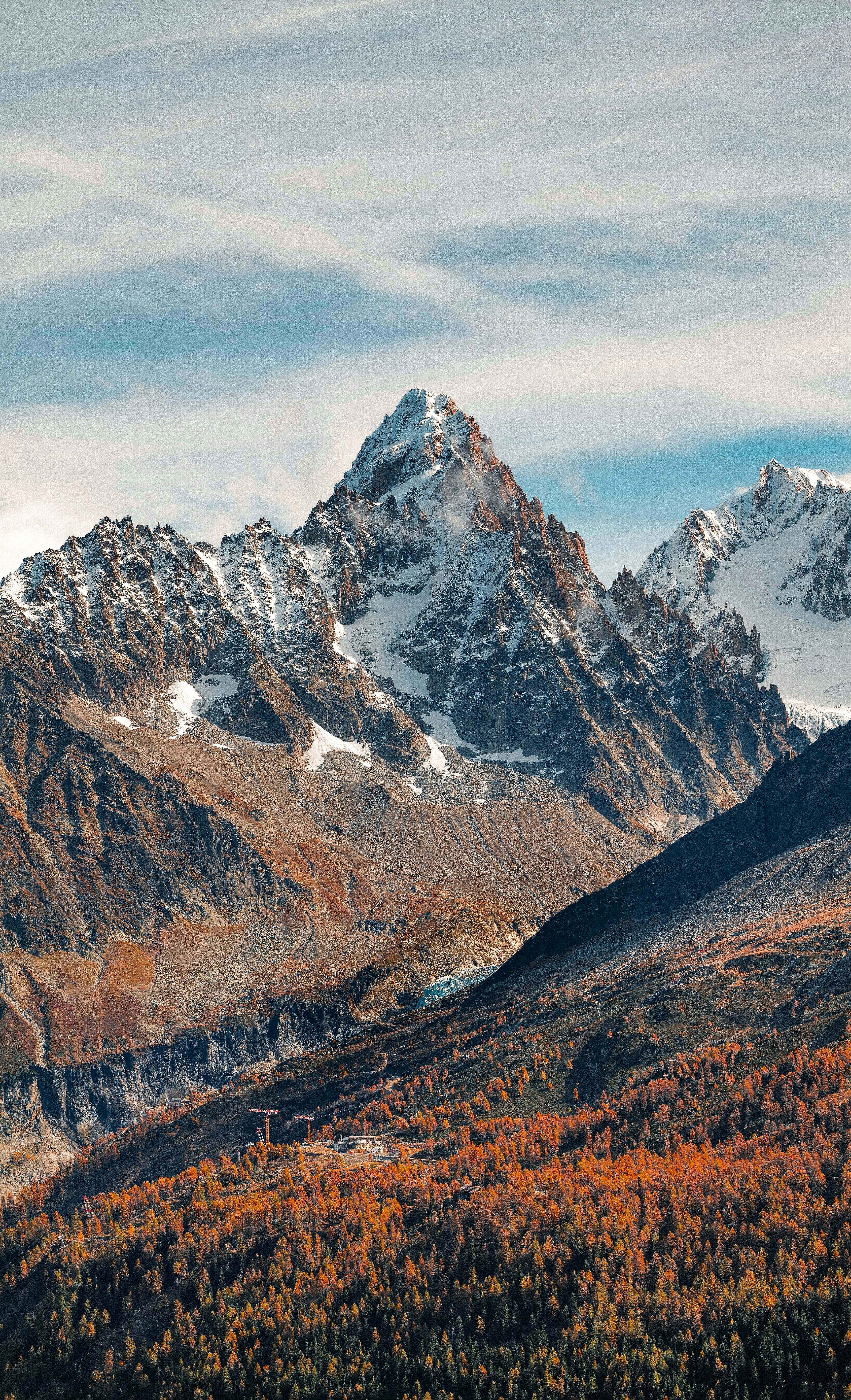 A view of a mountain range with trees in the foreground
