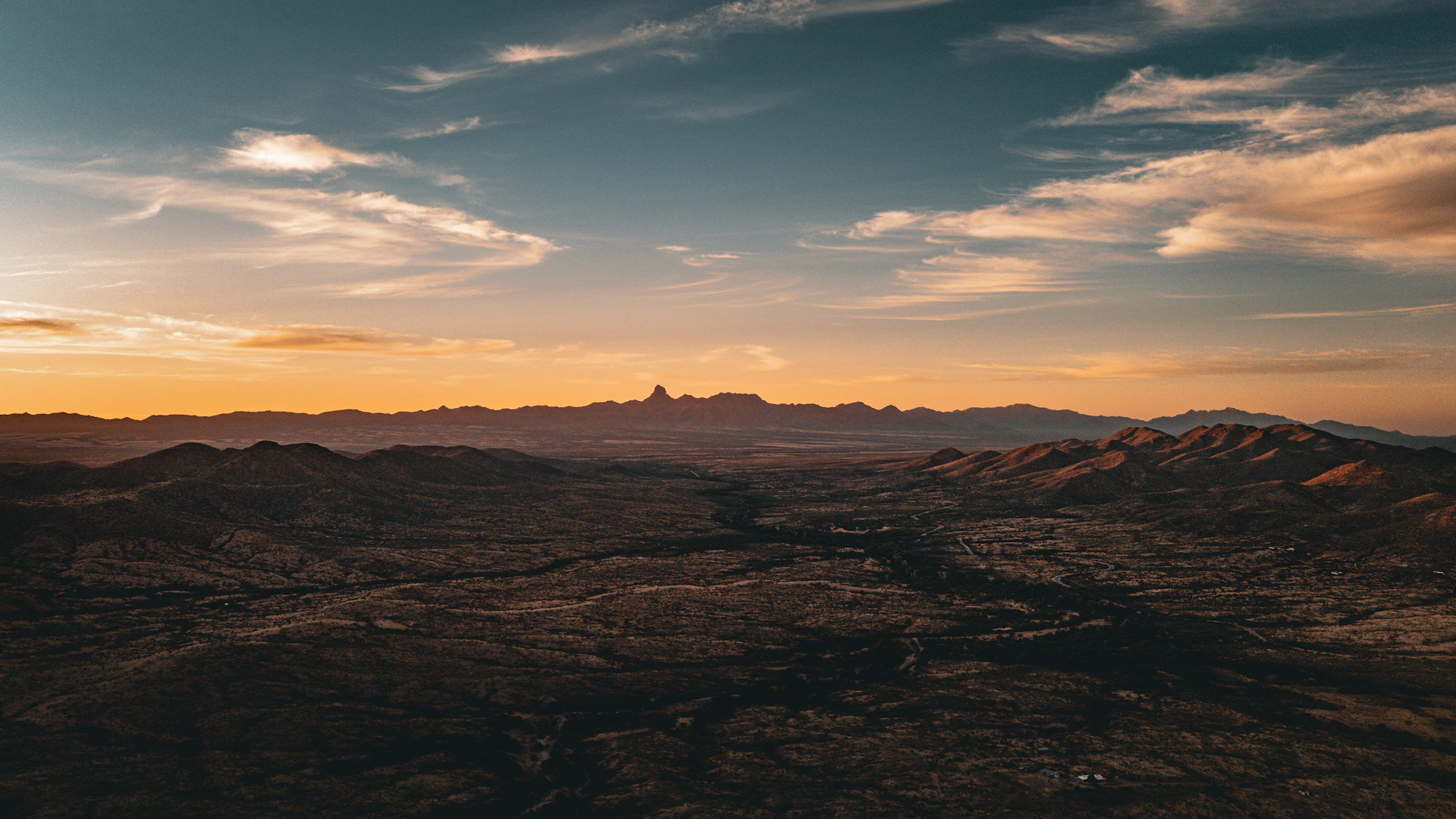 The sun is setting over a mountain range