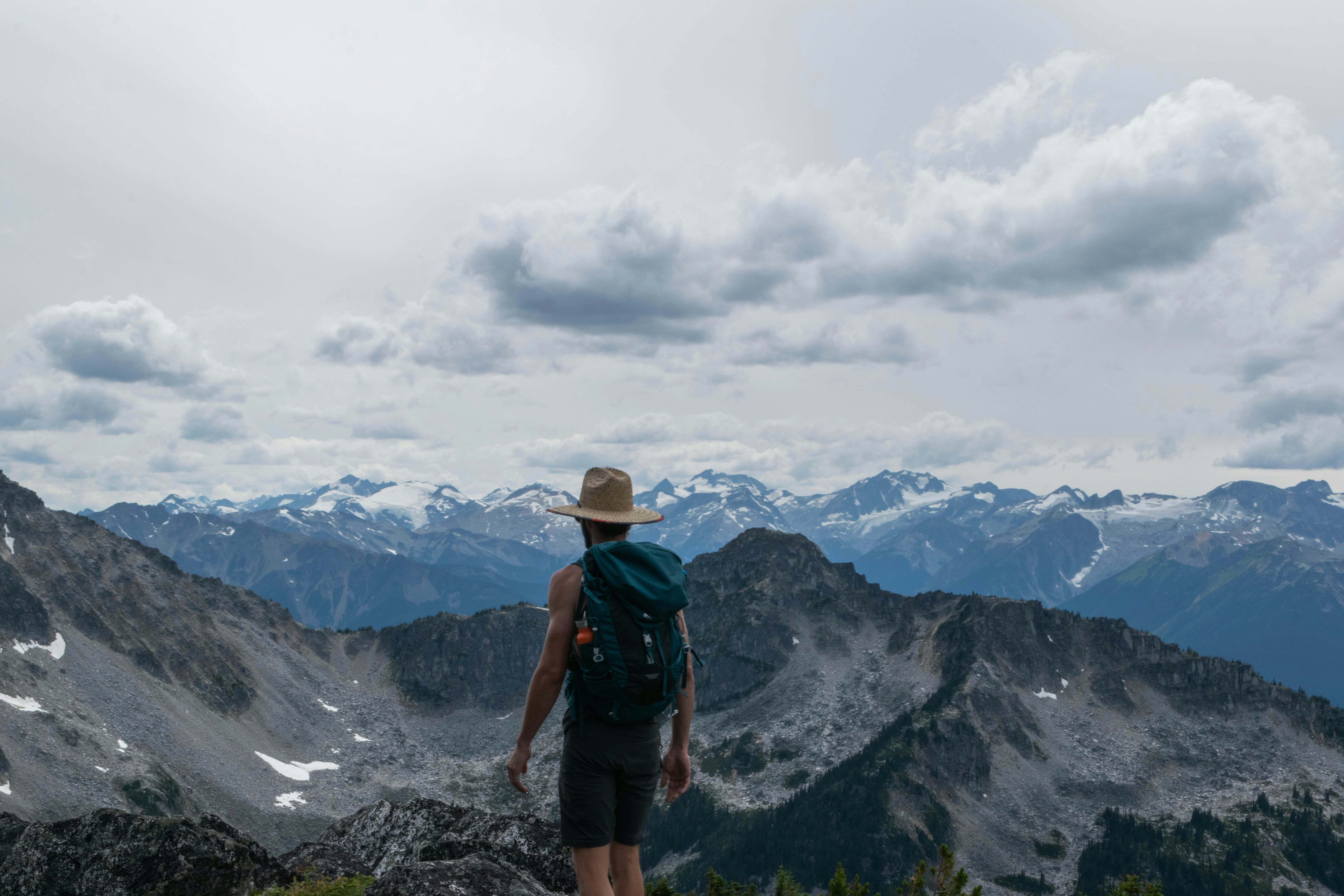 A man with a backpack standing on top of a mountain