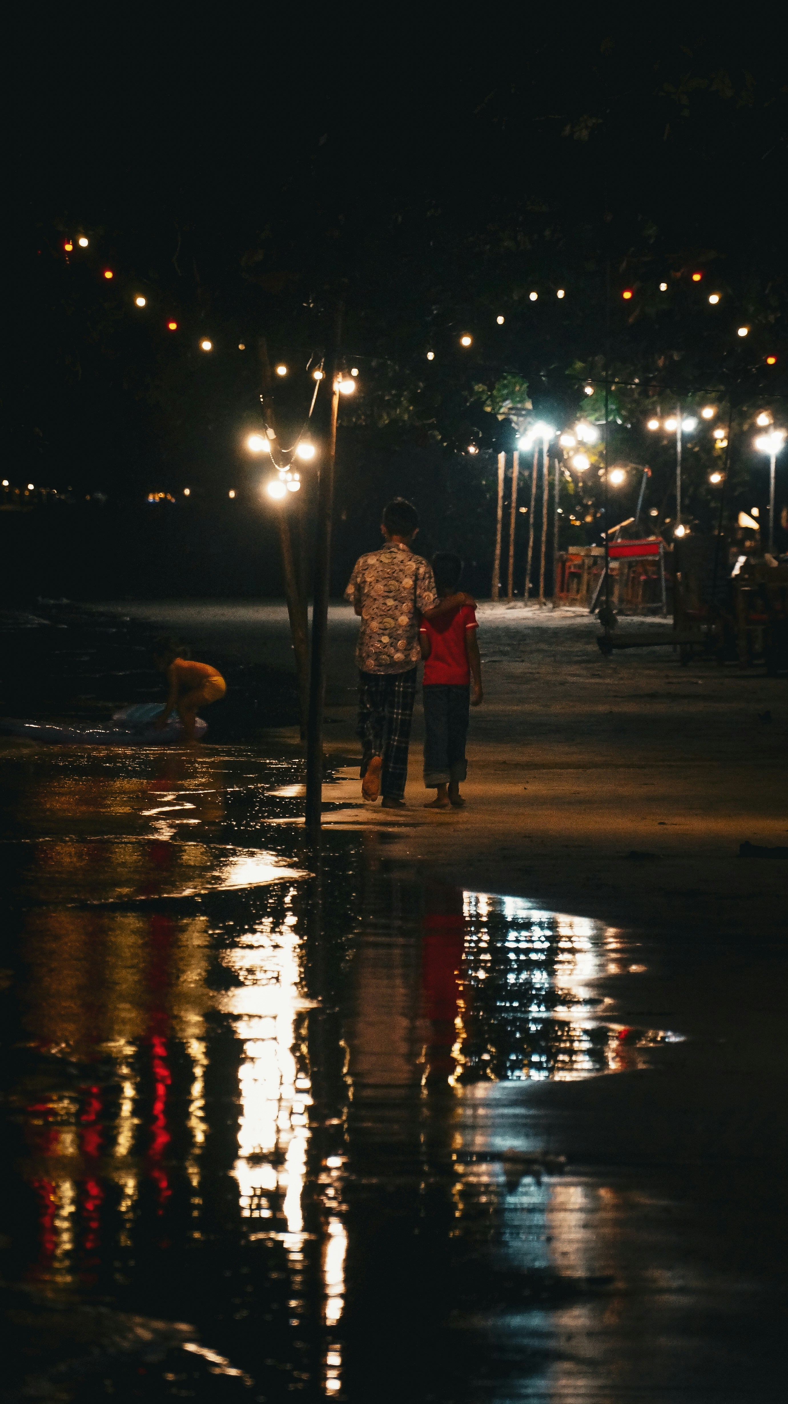 A man and a woman walking down a street at night