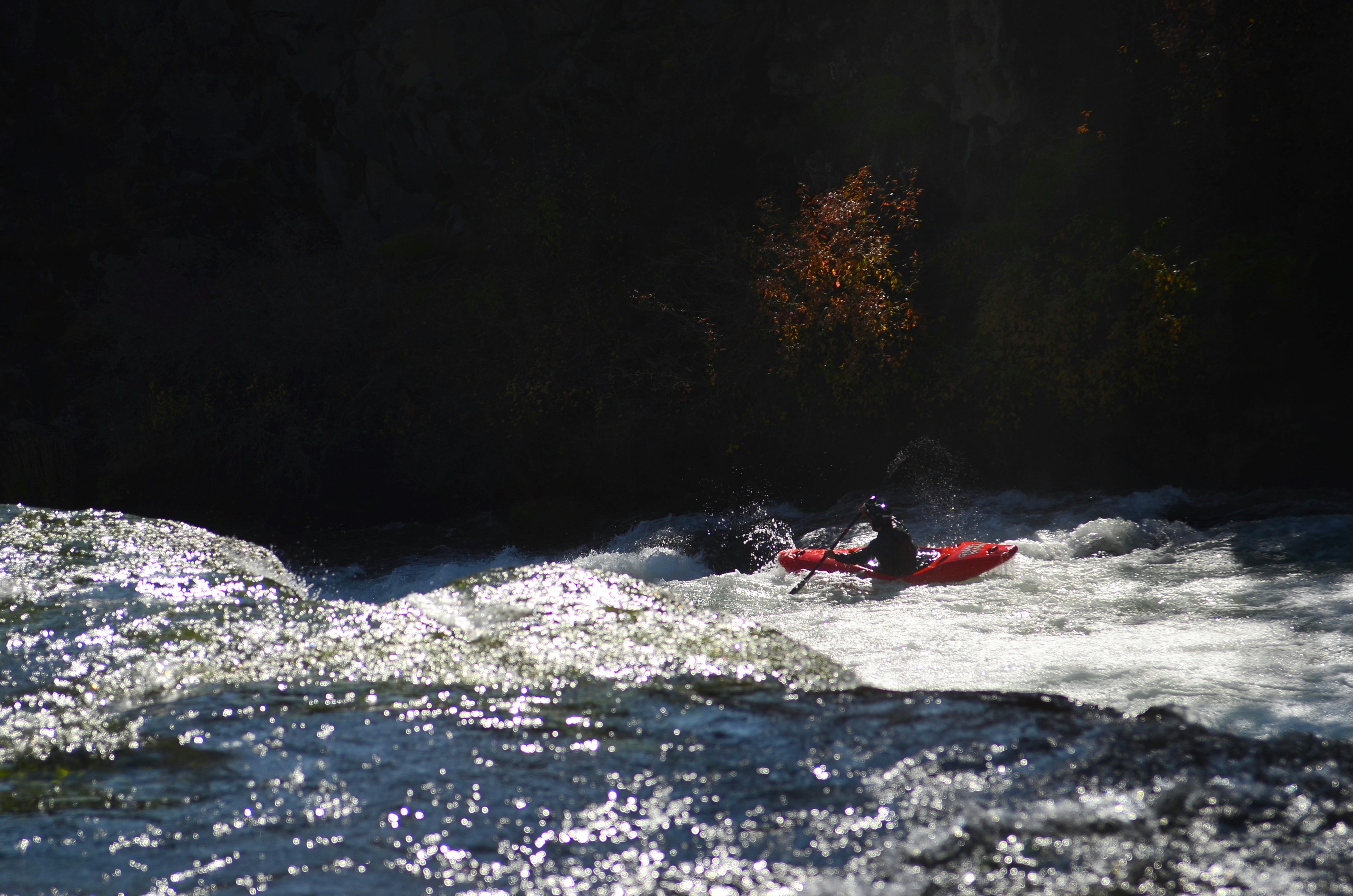 A person in a red boat on a river