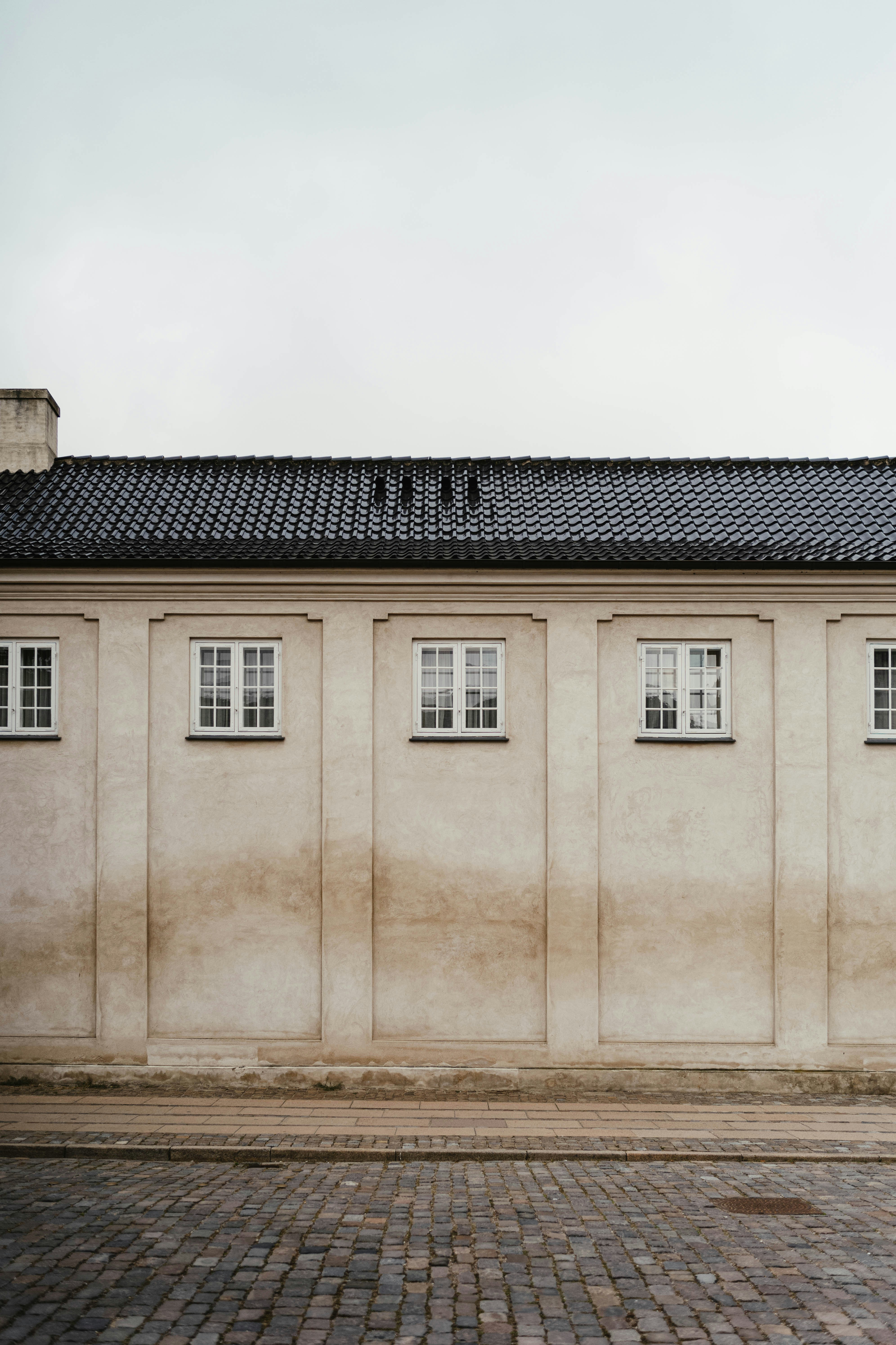 A man riding a skateboard past a tall building