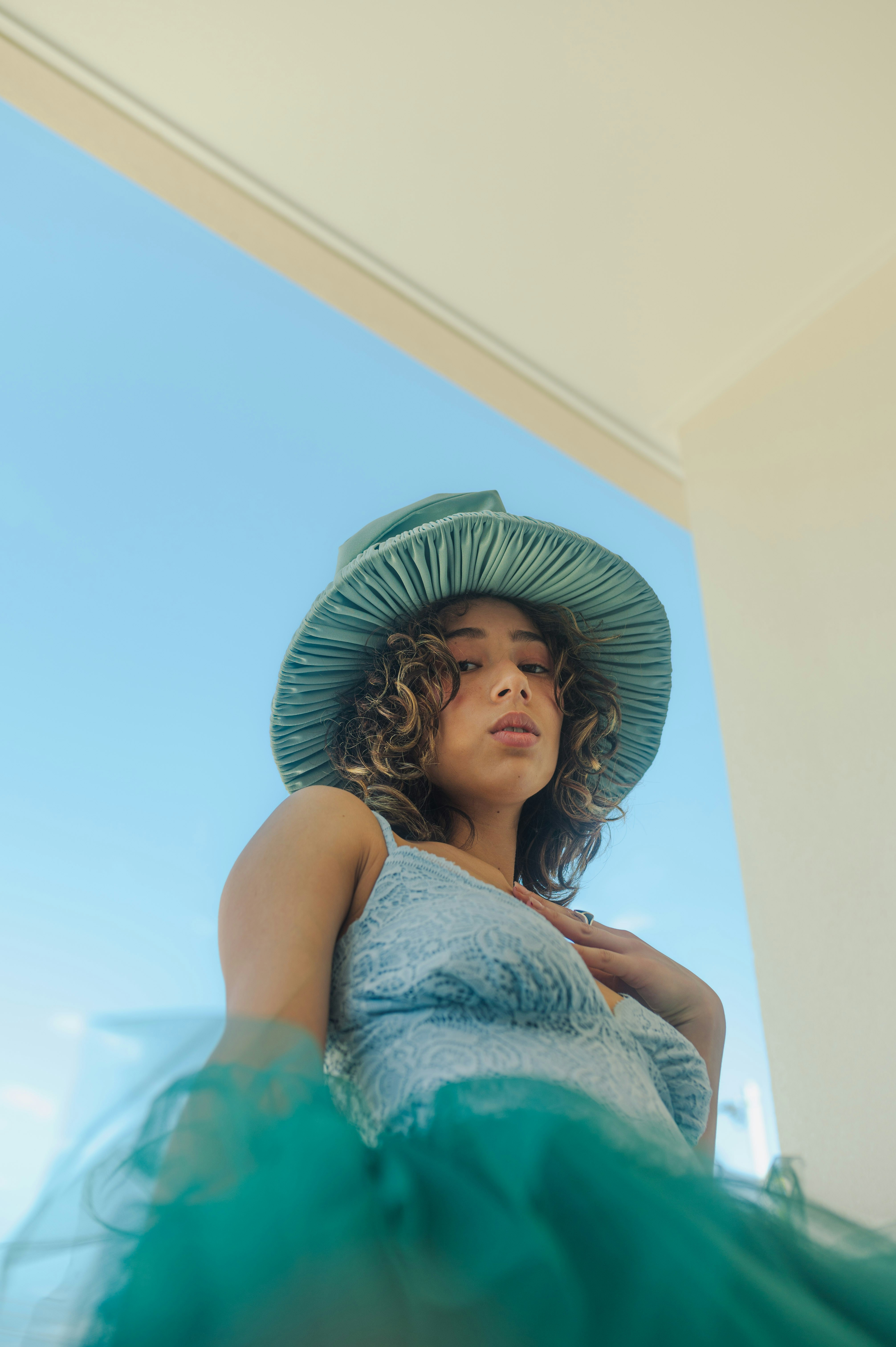 A woman in a blue dress and a green hat