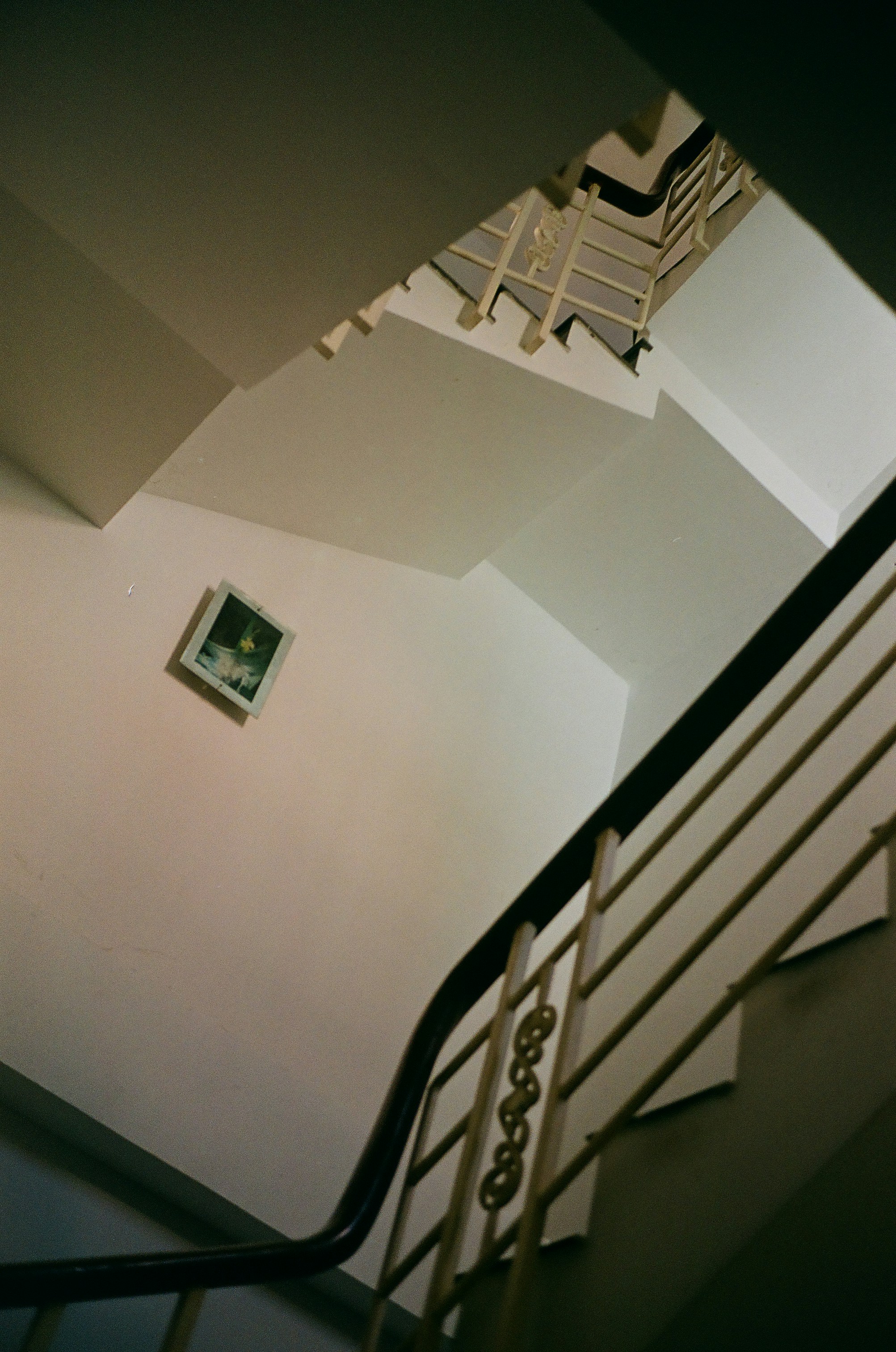 A stair case with a picture hanging on the wall