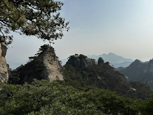 A view of a mountain range with trees and mountains in the background — Seoraksan & Sokcho, South Korea