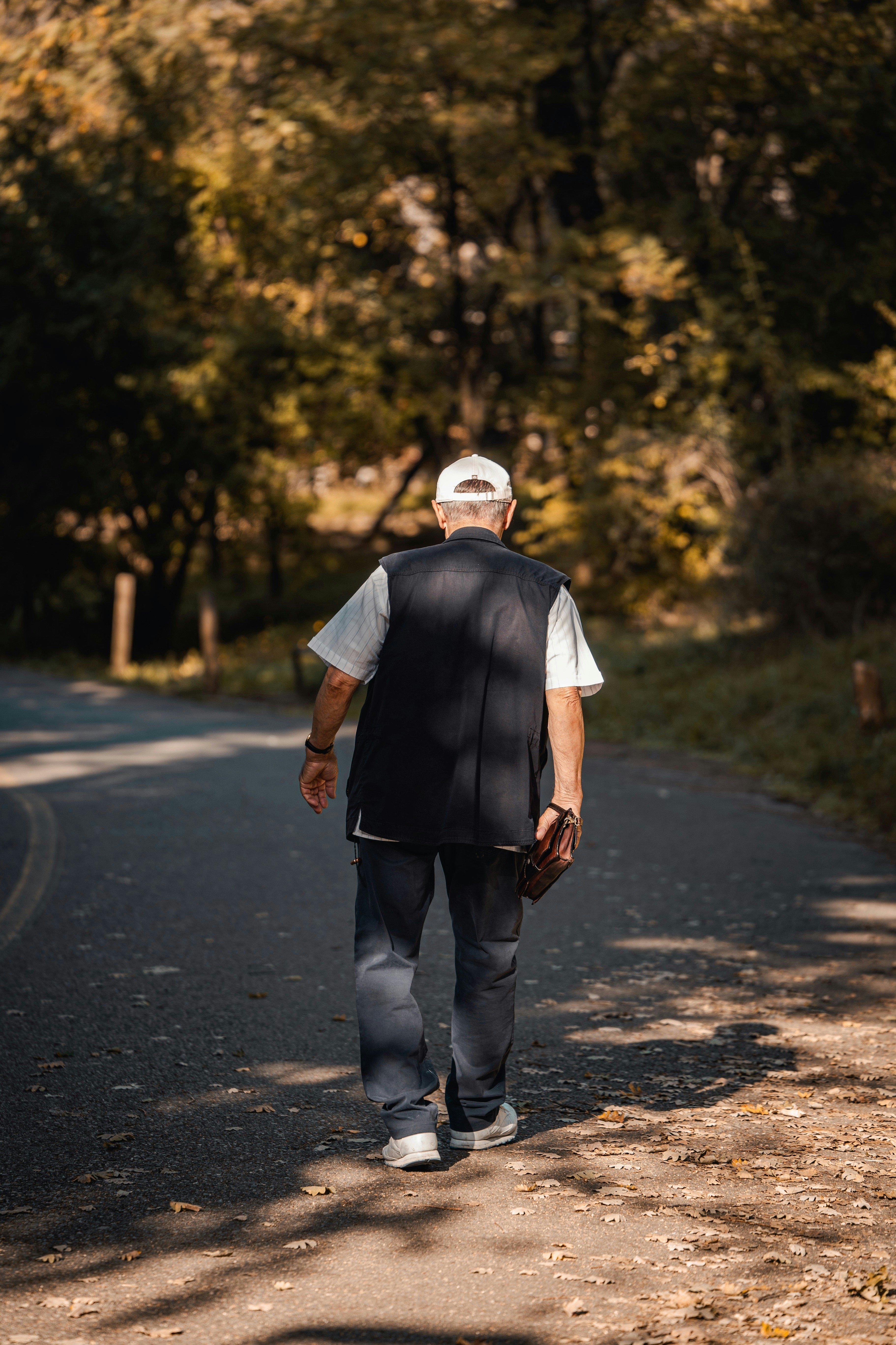 A man walking down a road in the woods