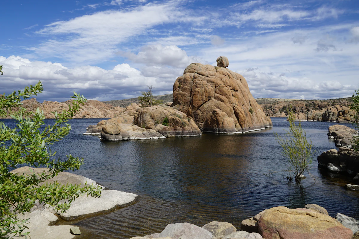 Granite boulders rising out of Watson Lake in Prescott under white clouds