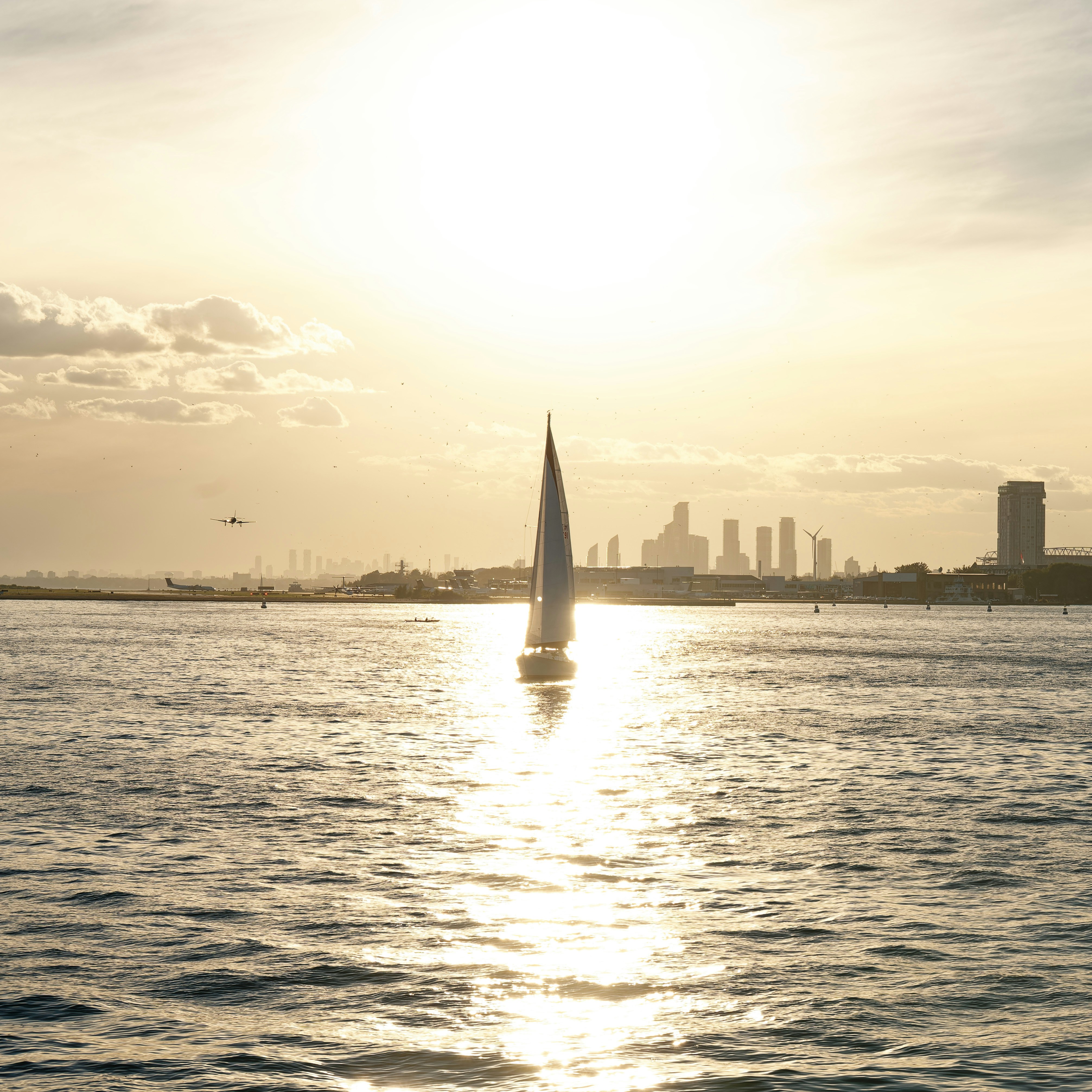 Una barca a vela nell'acqua con una città sullo sfondo