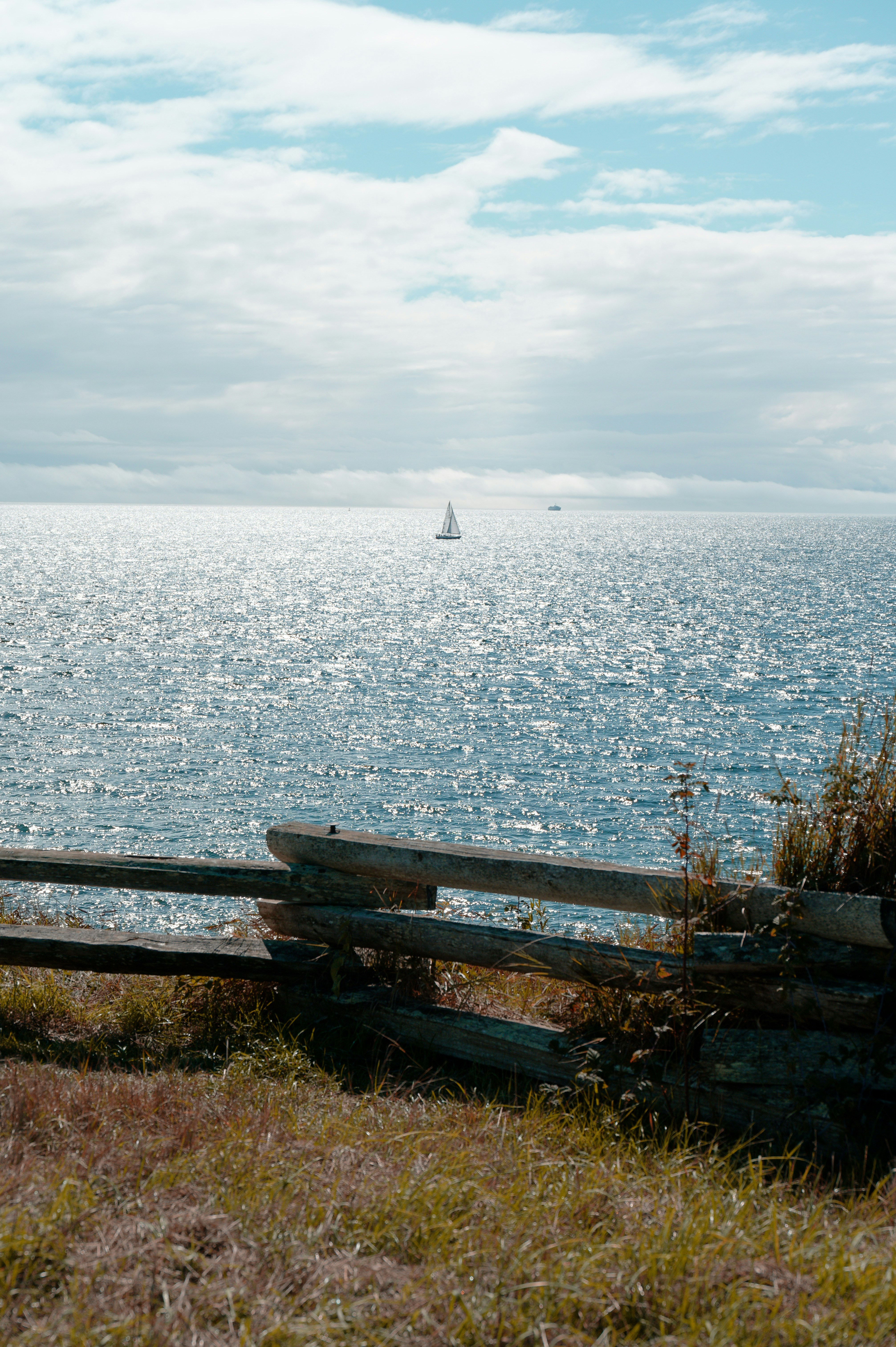 Una panchina di legno seduta in cima a una collina ricoperta d'erba