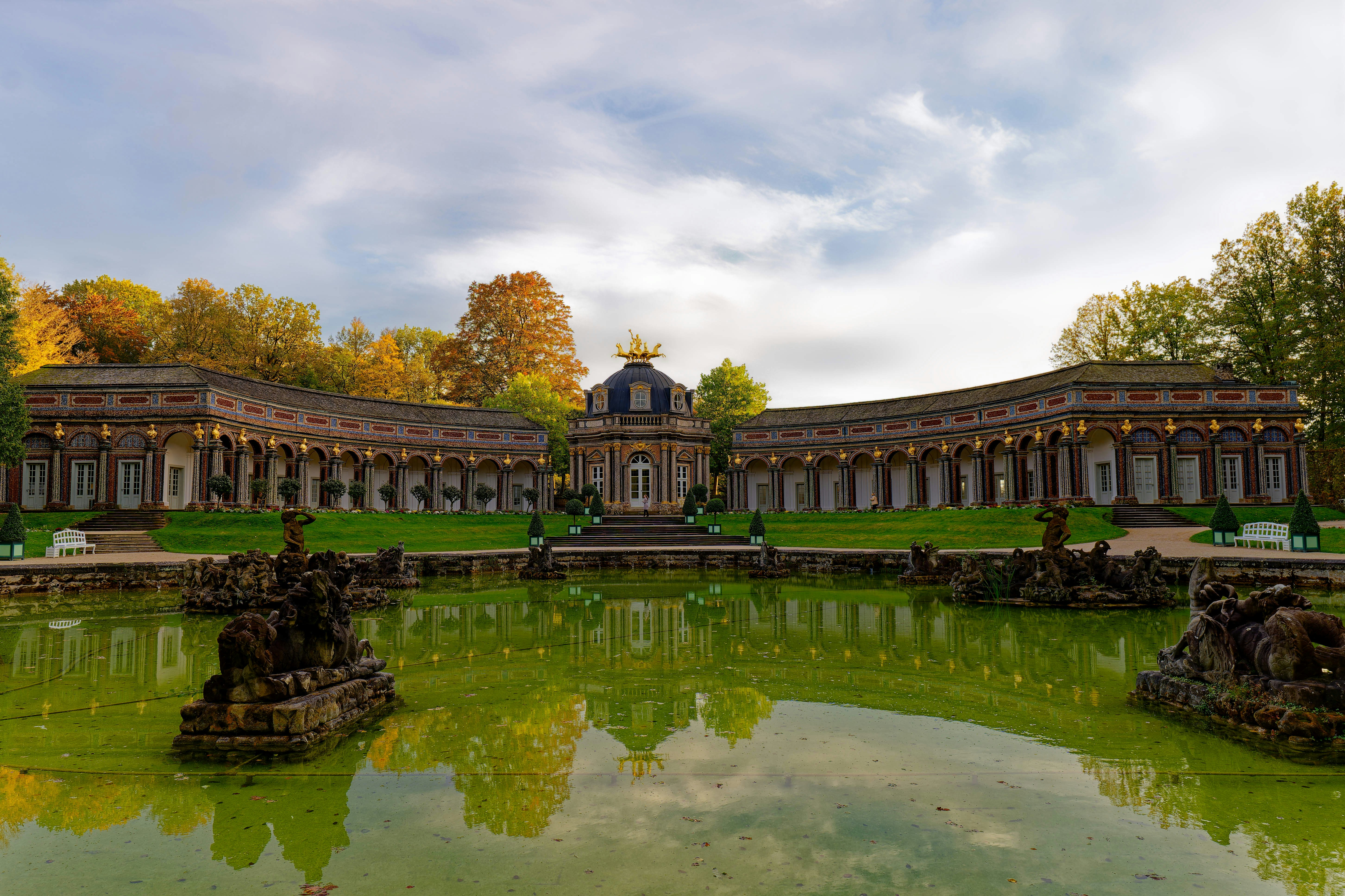 A large building with a pond in front of it