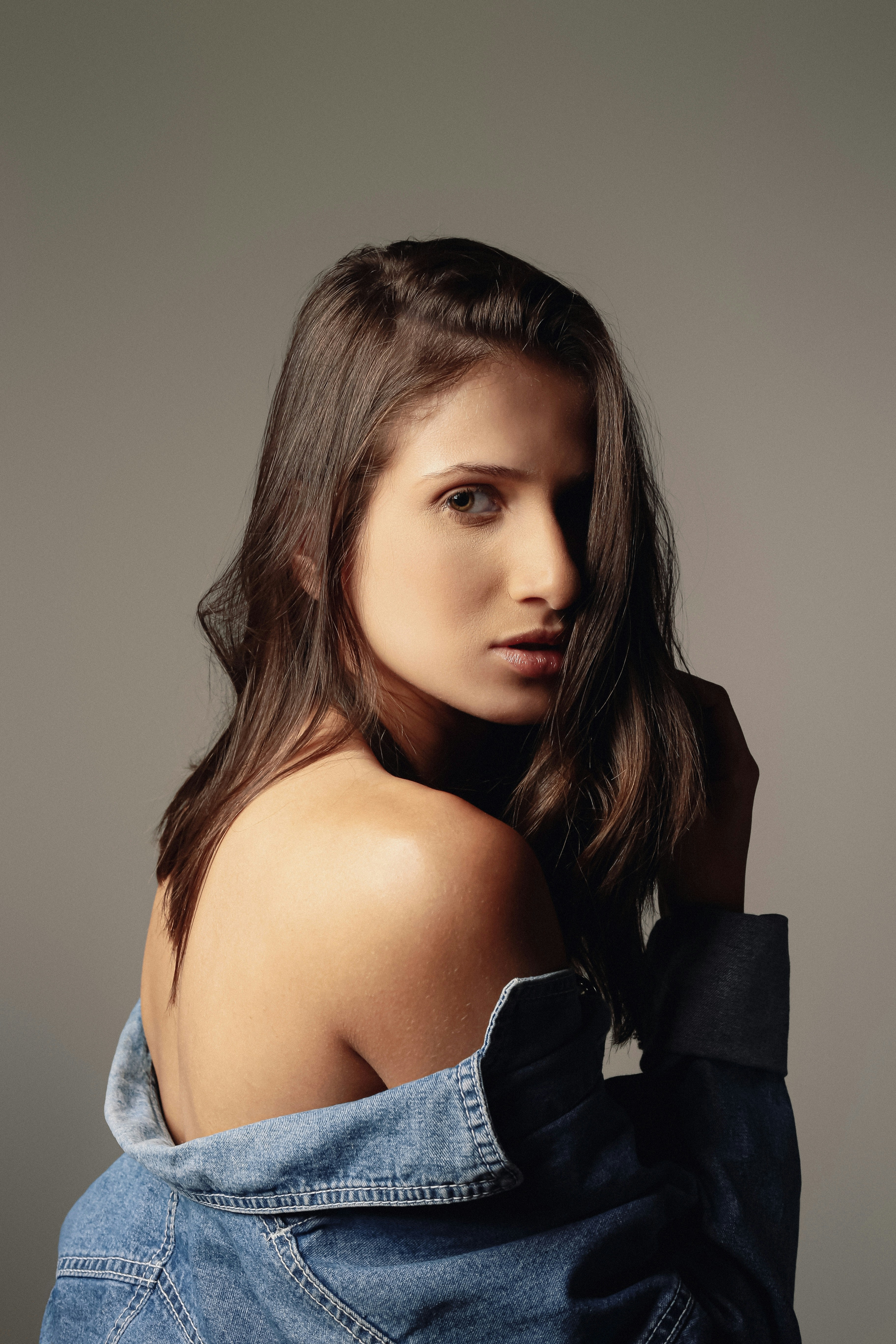 A woman in a jean jacket posing for a picture