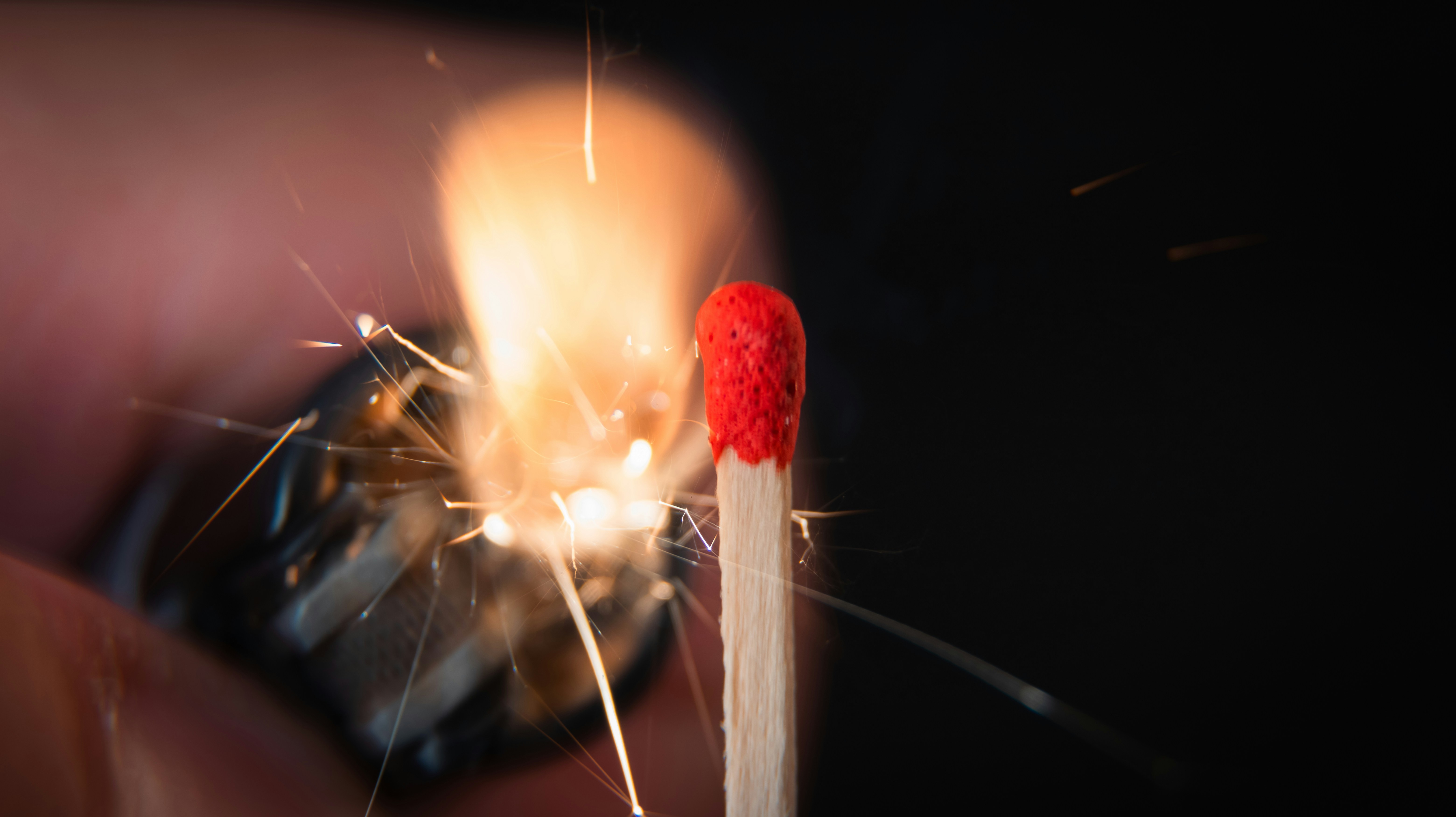 A person holding a lit match stick in their hand
