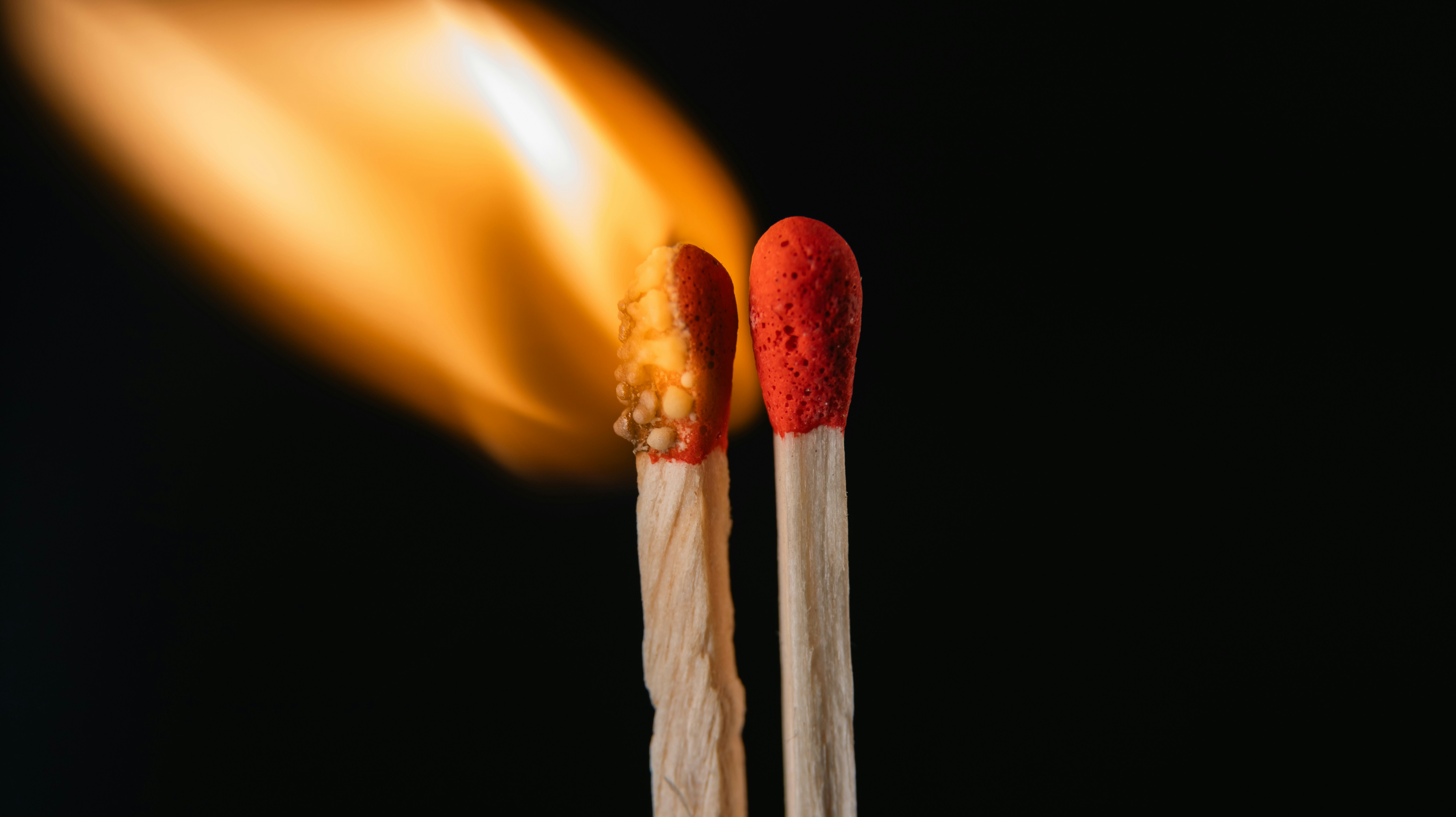 A close up of two matches on a black background