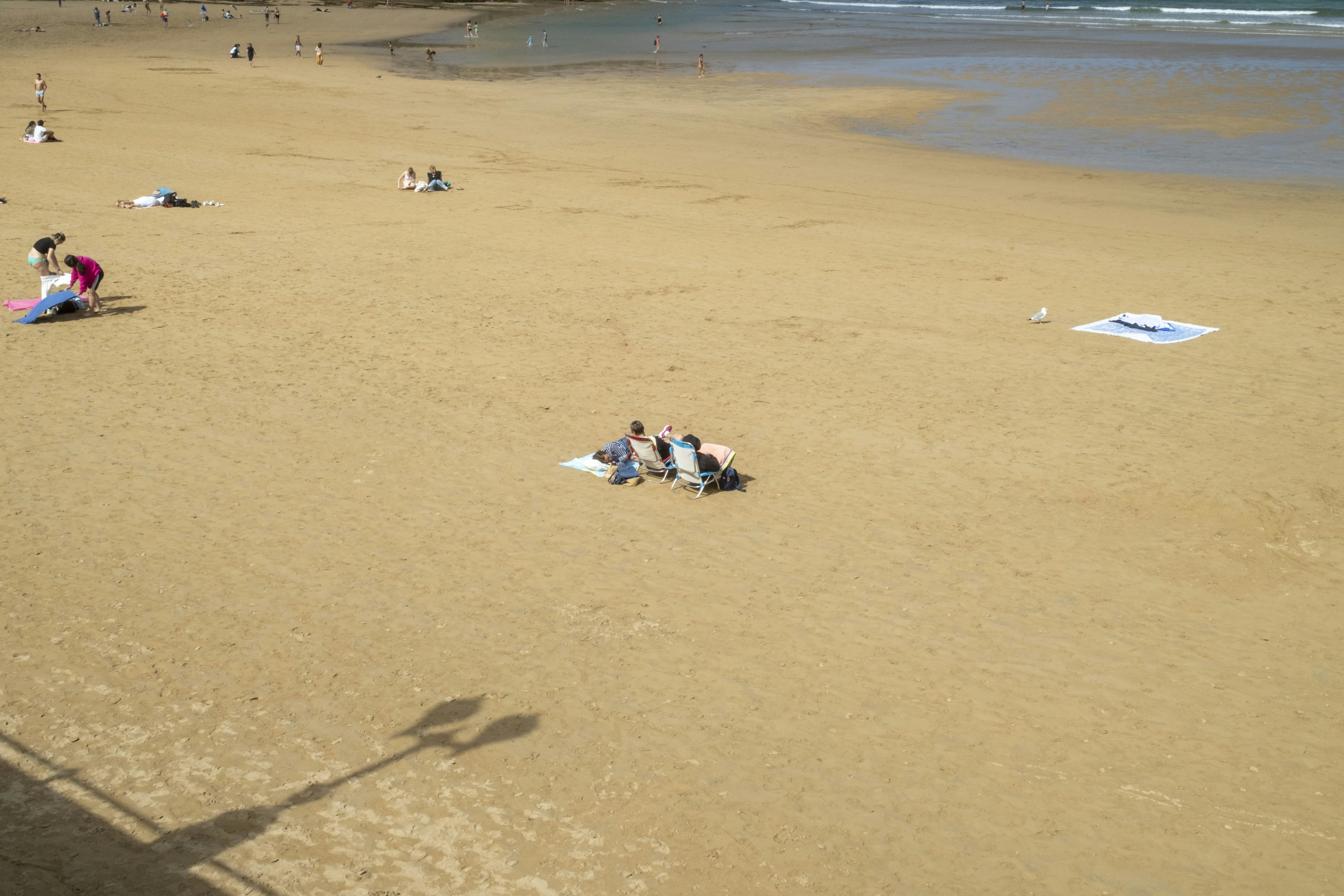 Eine Gruppe von Menschen, die auf einem Sandstrand sitzen