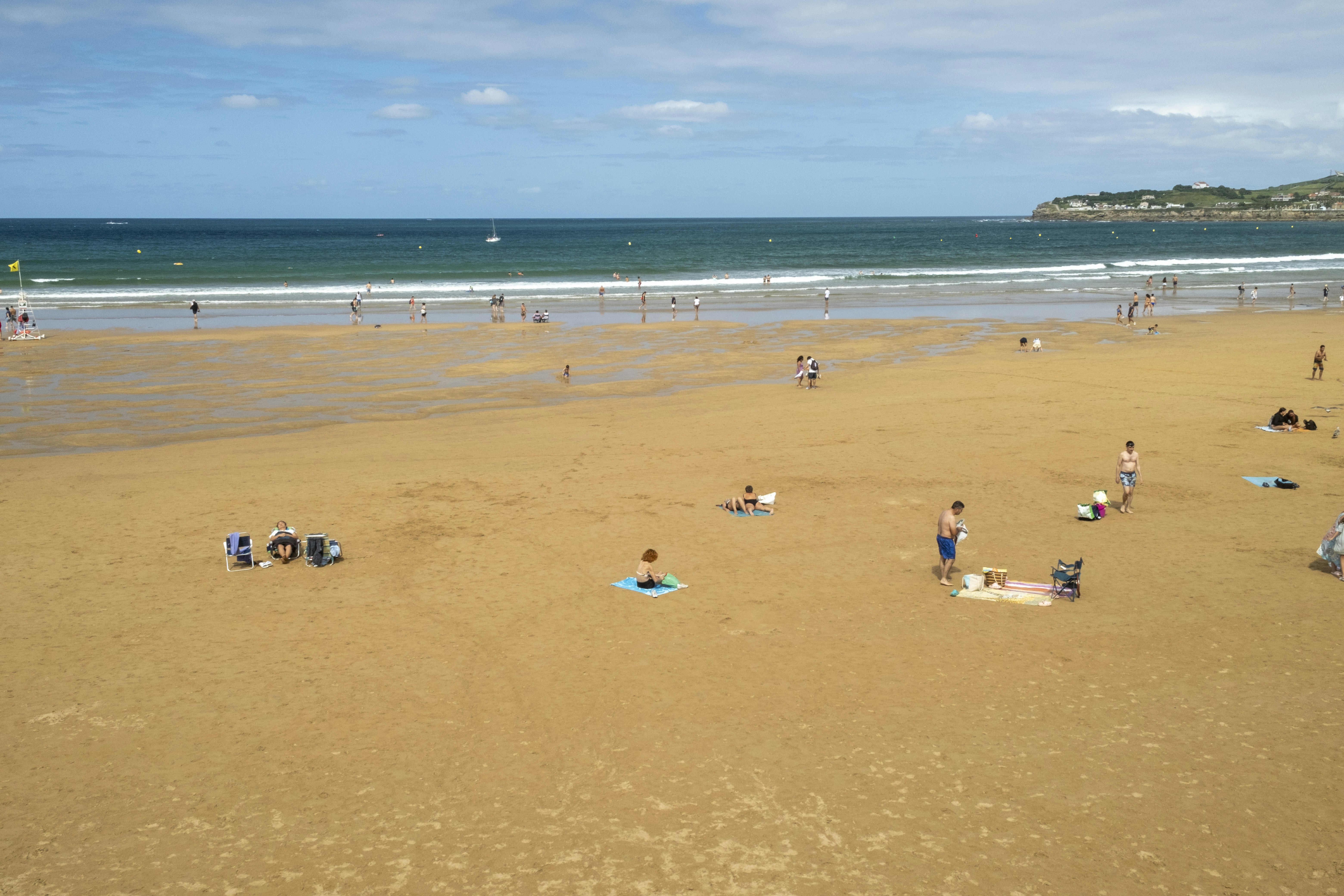Eine Gruppe von Menschen an einem Strand mit dem Meer im Hintergrund