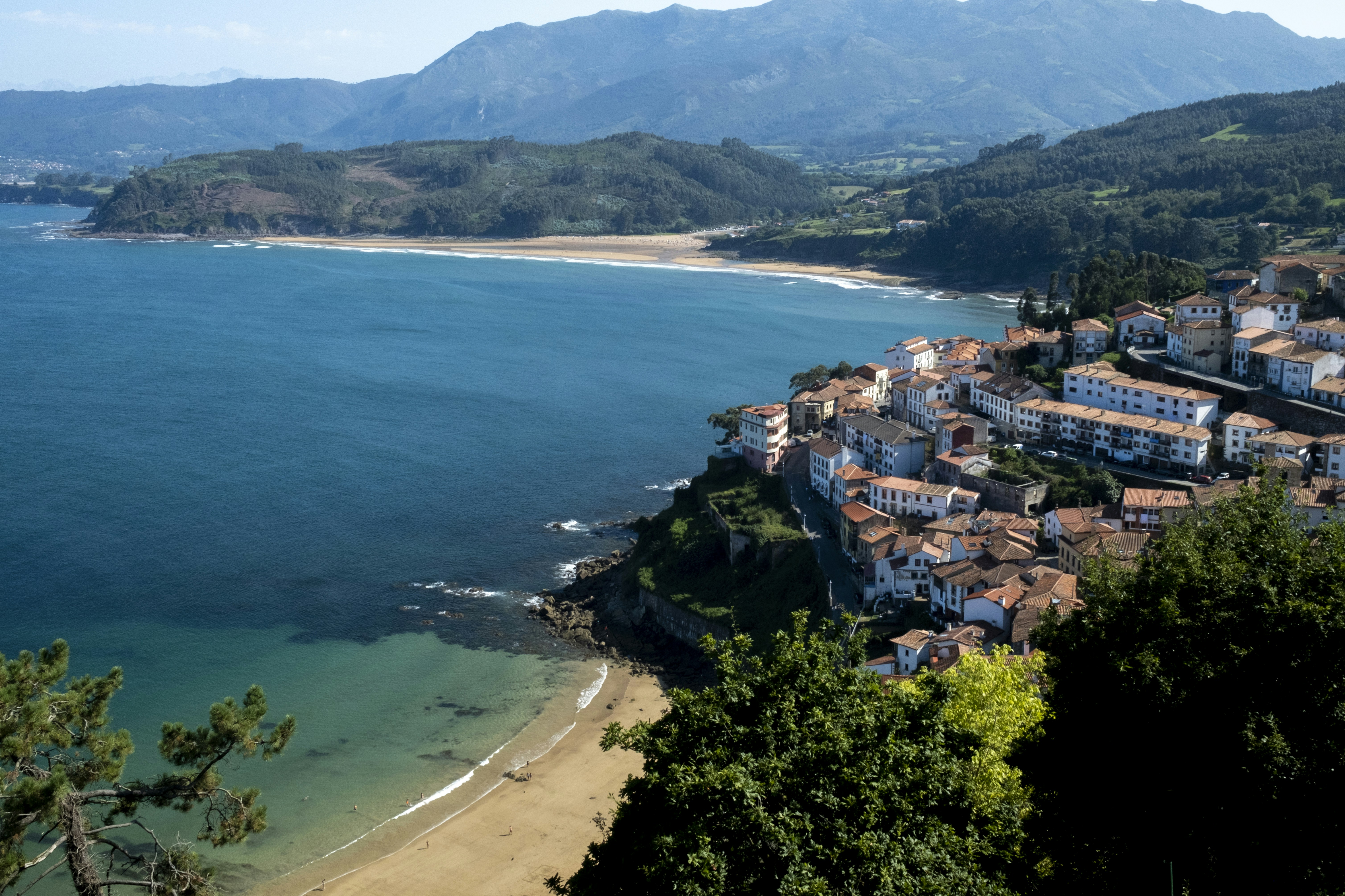 Blick auf einen Strand und eine Stadt von einem Hügel aus